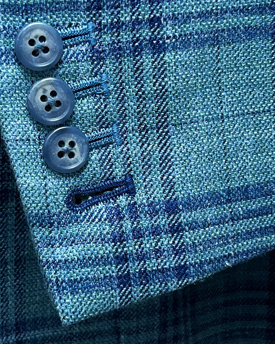 Close-up of the men's sportcoat's functional sleeve buttonholes with dark blue accent stitching.