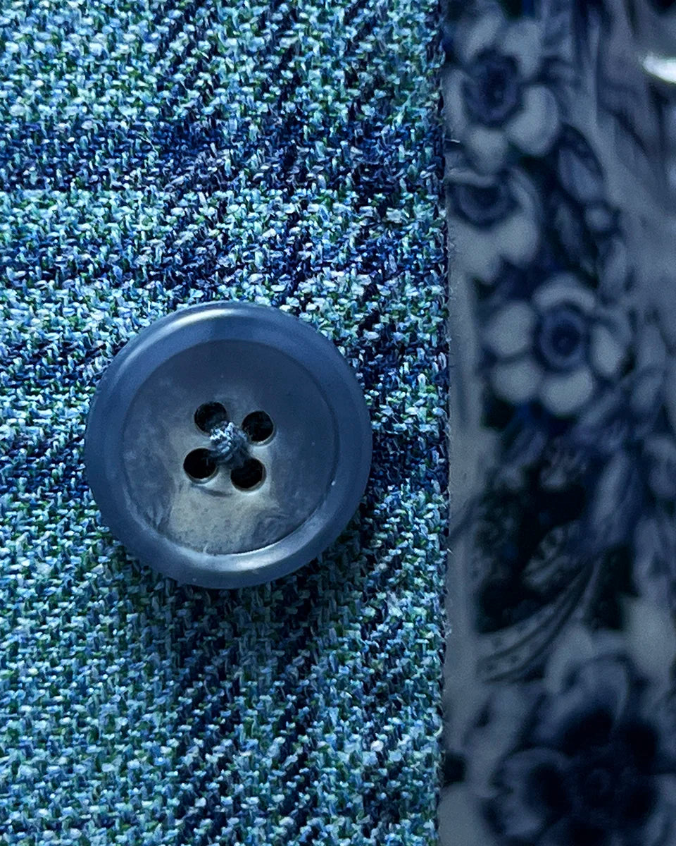 Detailed view of the turquoise marble horn buttons on the men's sportcoat.