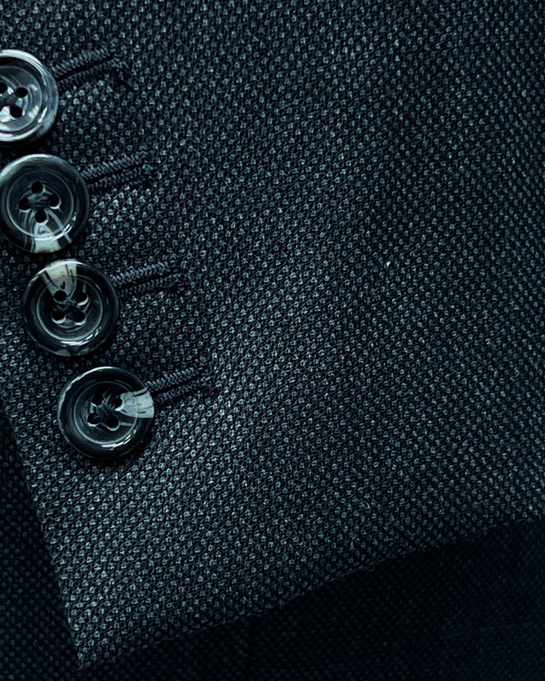 Dark grey birdseye custom suit, close-up of the sleeve cuffs and buttons for work attire