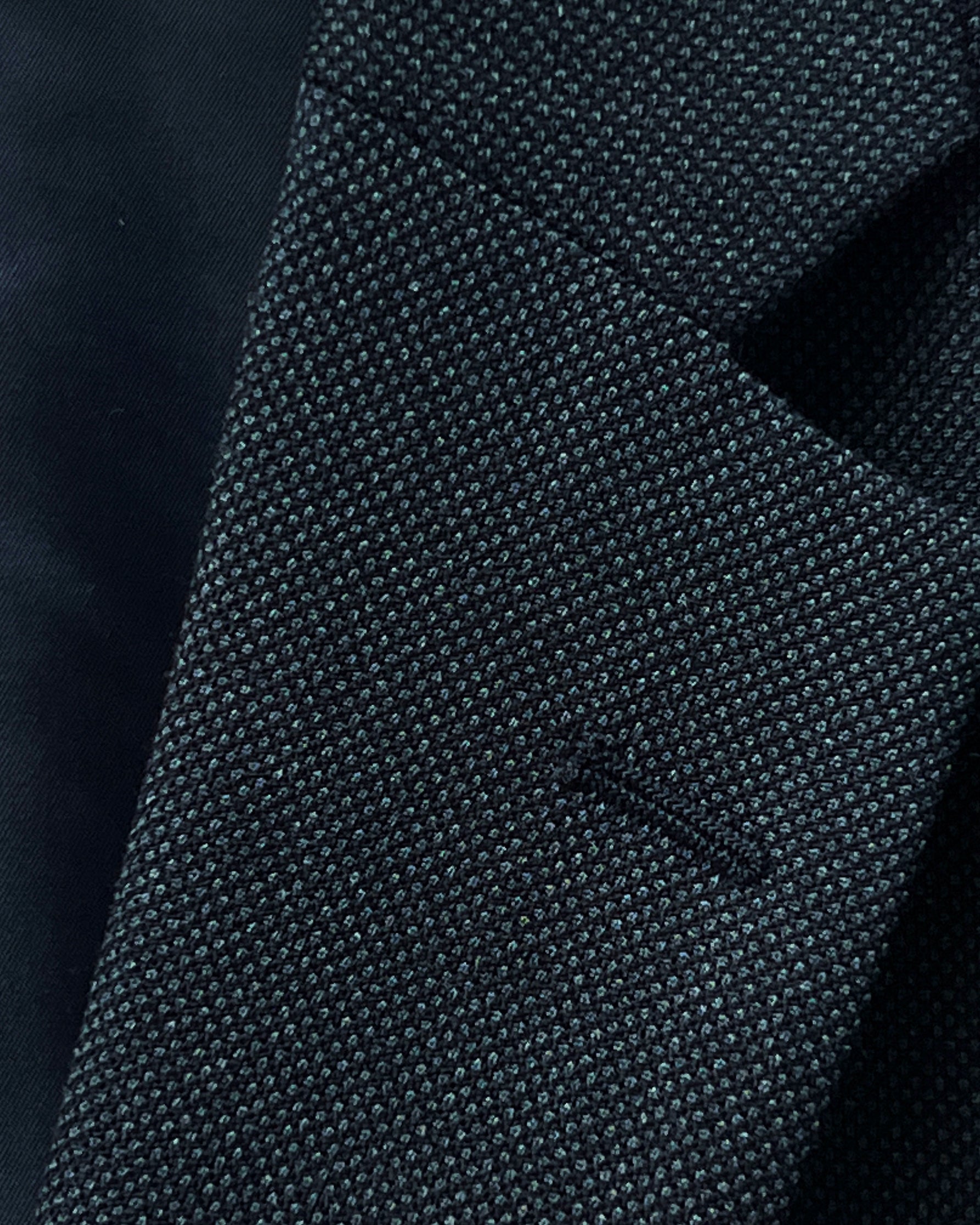 Dark grey birdseye custom suit, detailed view of the lapel and buttonhole, ideal for online design