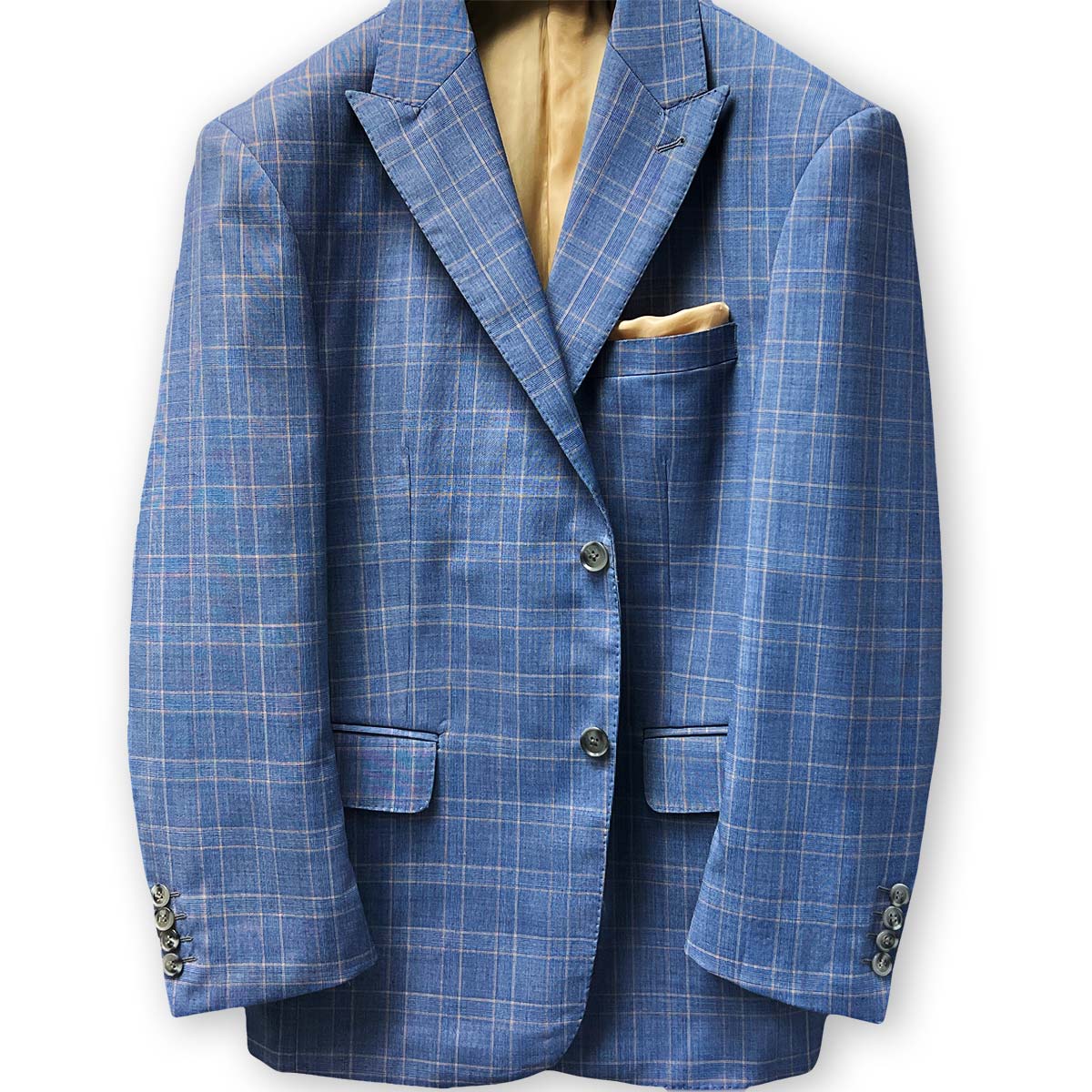 Lapel buttonhole detail on a stone blue suit with tan windowpane plaid.