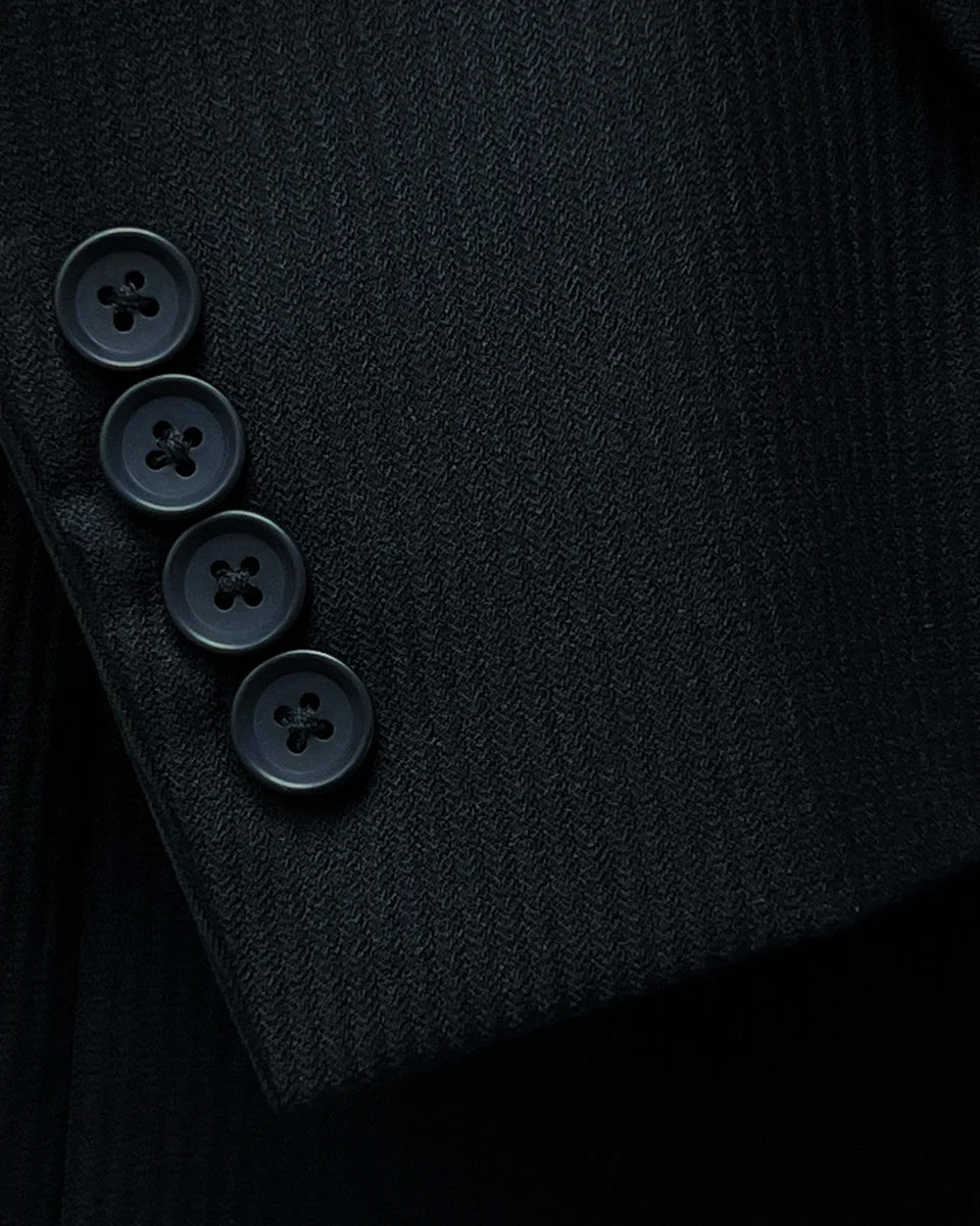 Close-up of the functional sleeve buttonholes, featuring the black horn buttons and careful tailoring.