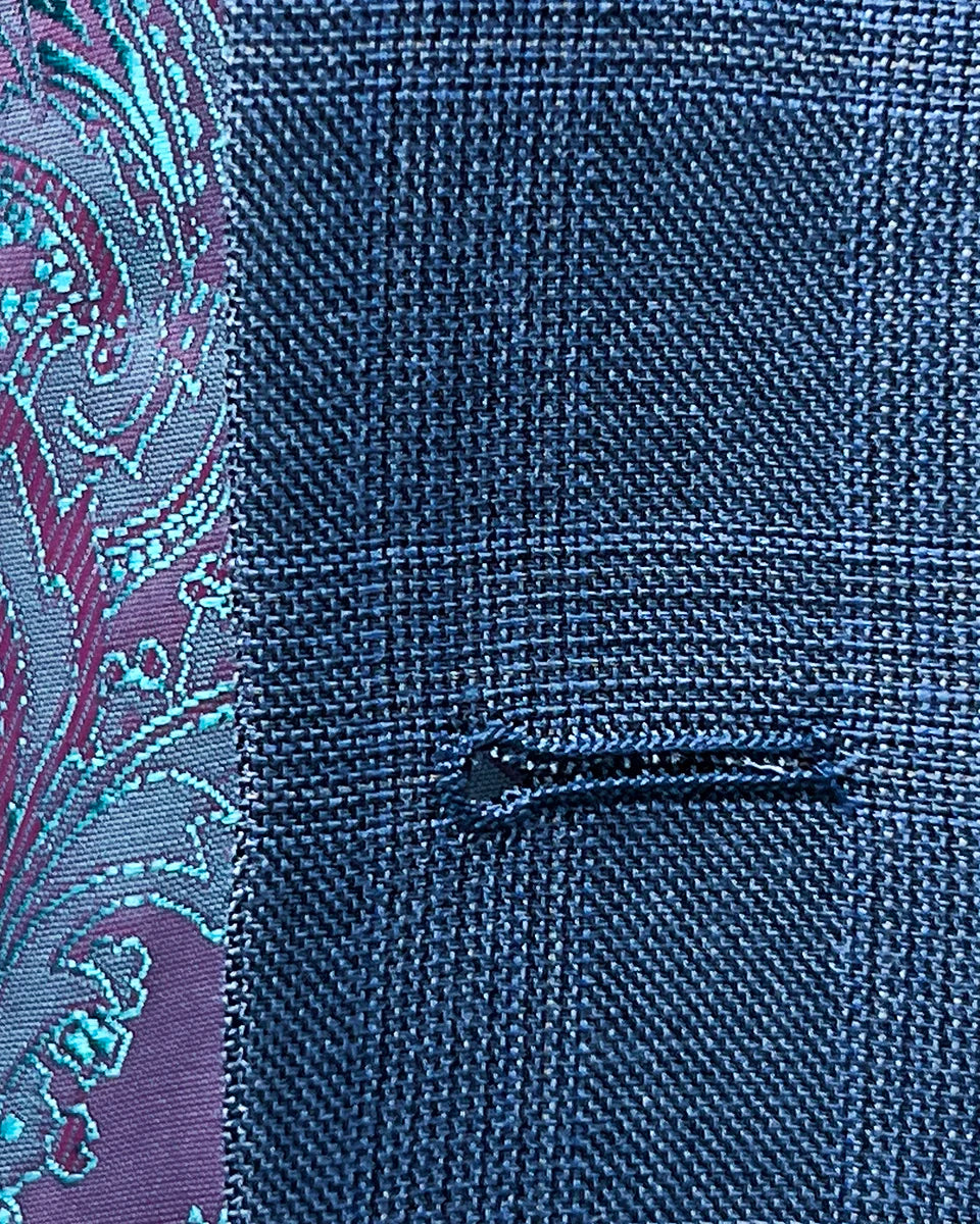Detail of the buttonhole stitching on the suit jacket, highlighting the craftsmanship and quality.
