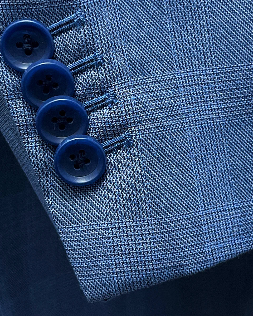 Close-up of the functional overlapping kissing buttons on the sleeve of the suit jacket.