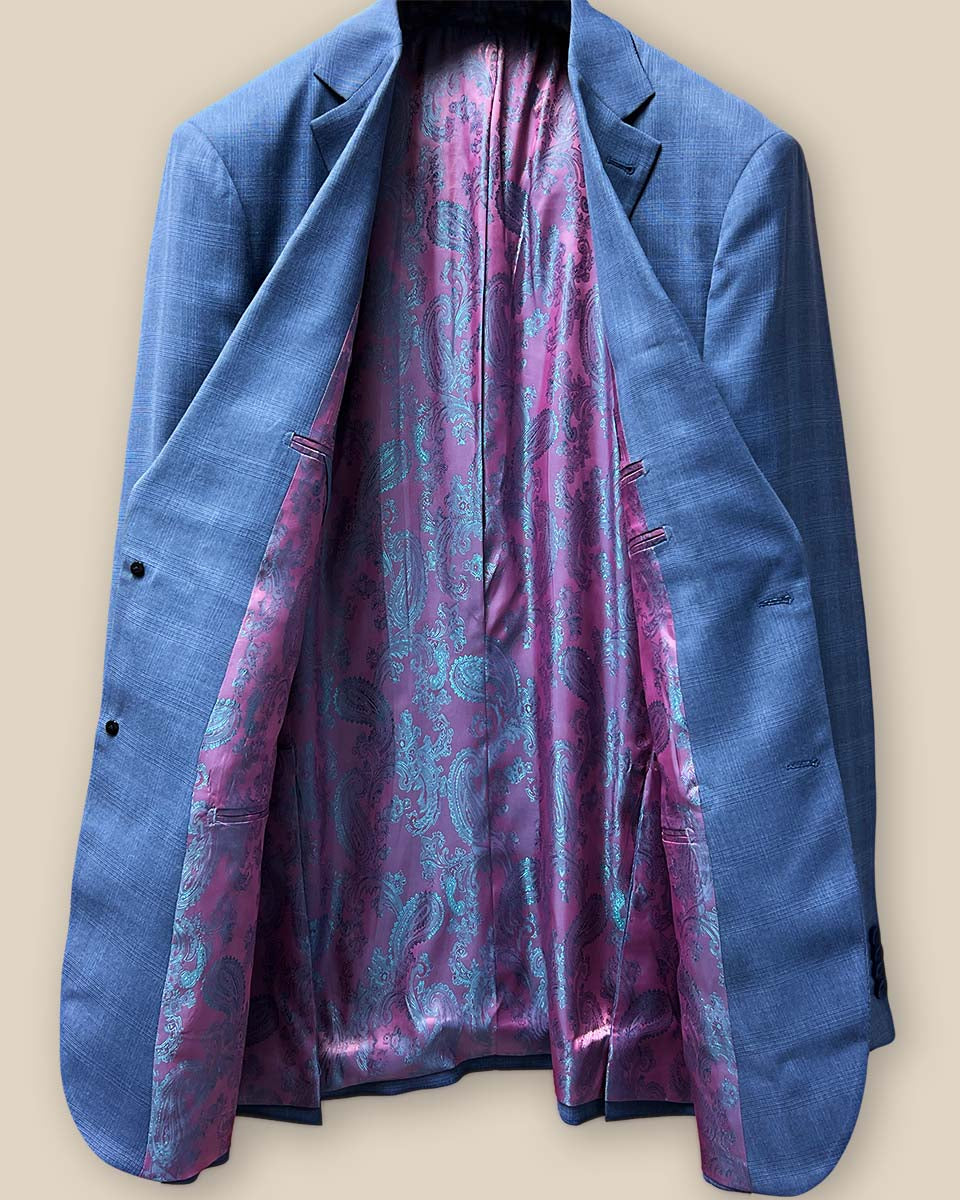 Full view of the interior lining of the suit jacket, featuring a vibrant pink and purple iridescent paisley pattern.