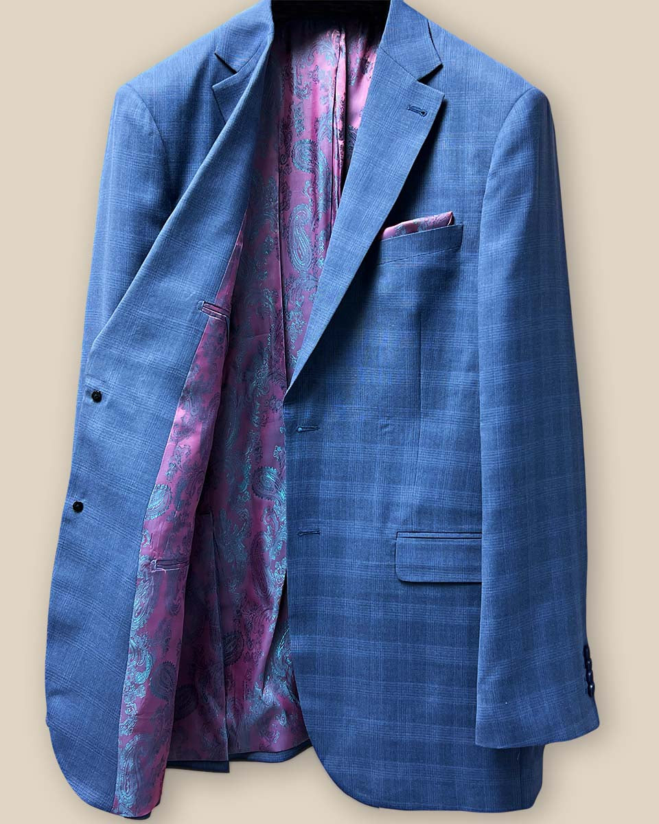 The inside right view of the suit jacket, with a focus on the intricate pink and purple paisley lining.