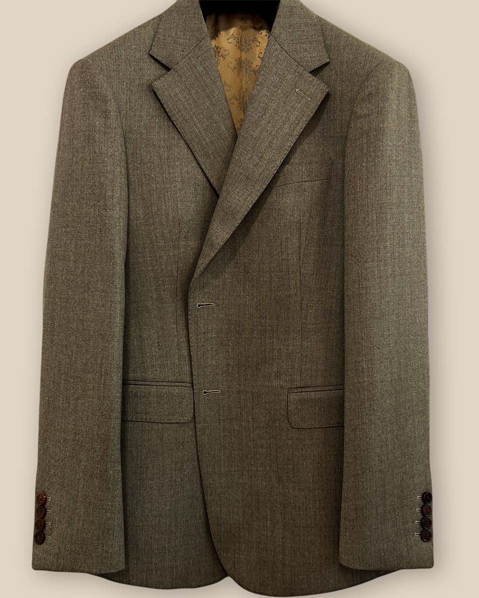 Close-up view of the jacket buttonhole panel on a Westwood Hart brown nailhead men's suit, showcasing fine stitching details.