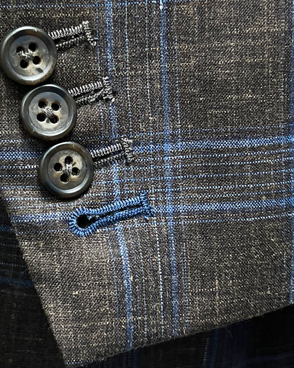 Detailed view of the functional sleeve buttonholes with blue accent stitching.