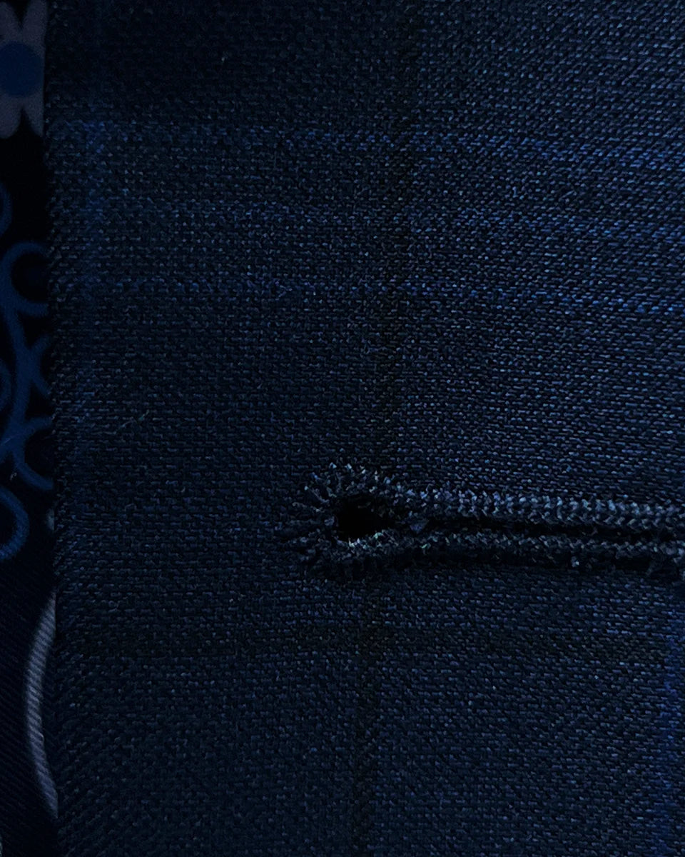 Detailed view of the buttonhole stitching on the dark blue windowpane men's sport coat featuring royal blue accent stitching.