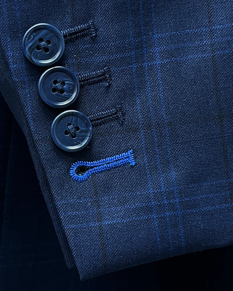 Close-up of the functional sleeve buttonholes on the dark blue windowpane men's sport coat with navy horn marble buttons.