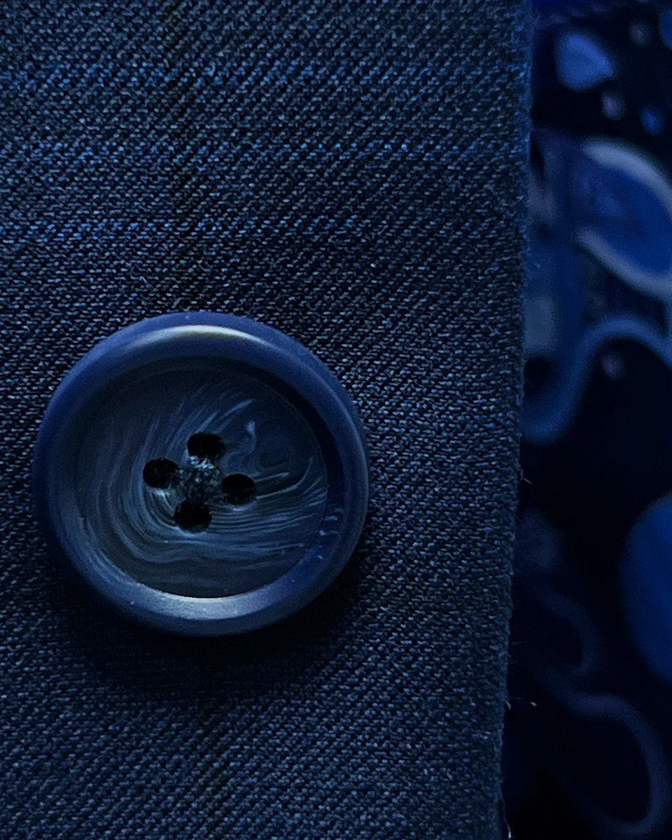 Close-up of the navy horn marble buttons on the dark blue windowpane men's sport coat.