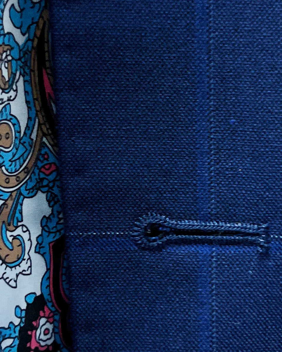 Detailed image of the hand pick stitching on the buttonholes, showcasing the white contrast thread on the royal blue fabric.