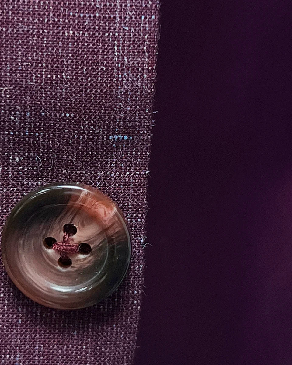 Burgundy horn buttons on a cranberry men's suit by Westwood Hart, highlighting quality and attention to detail.