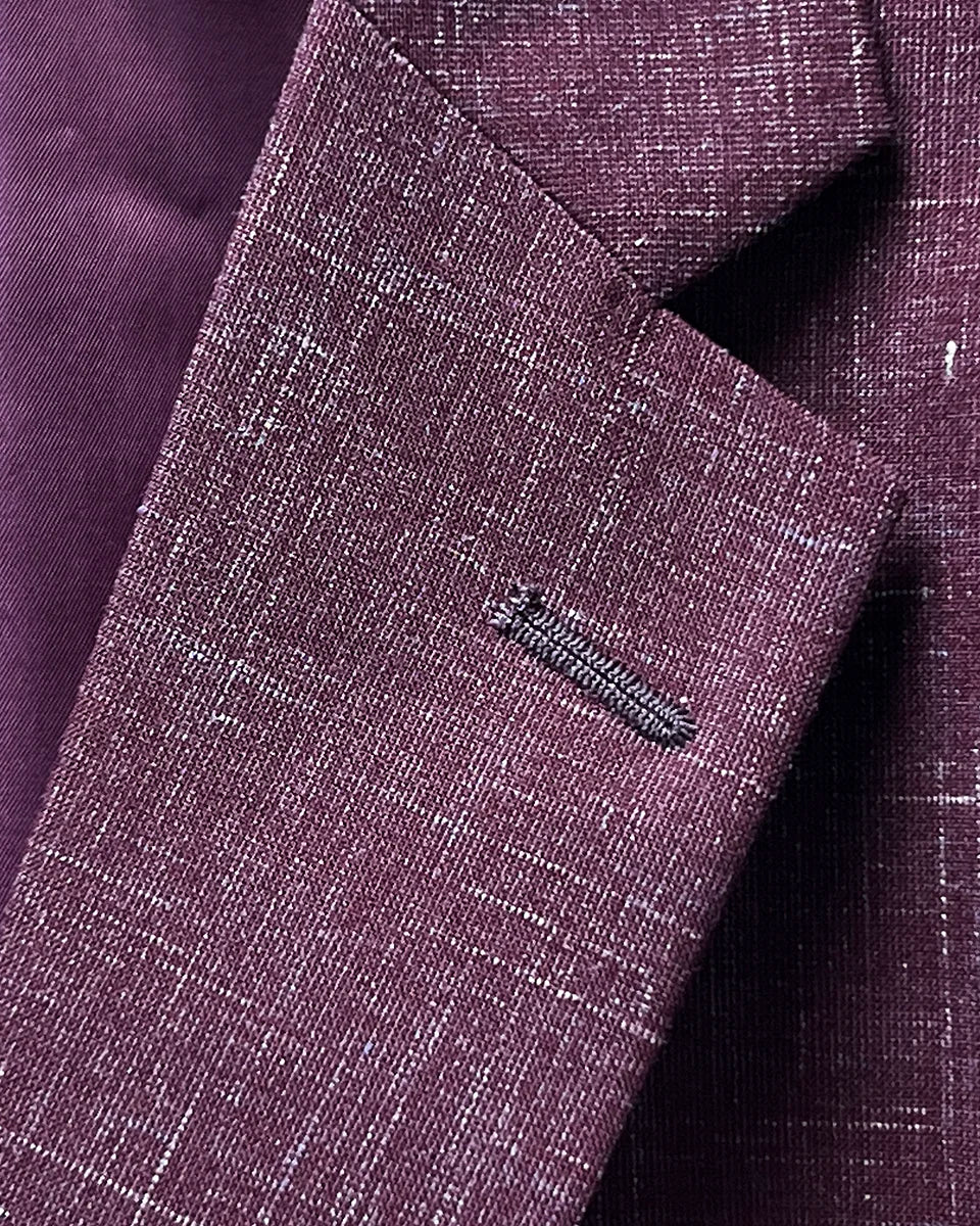 Notch lapel detail on a cranberry men's suit by Westwood Hart, reflecting classic tailoring and style.