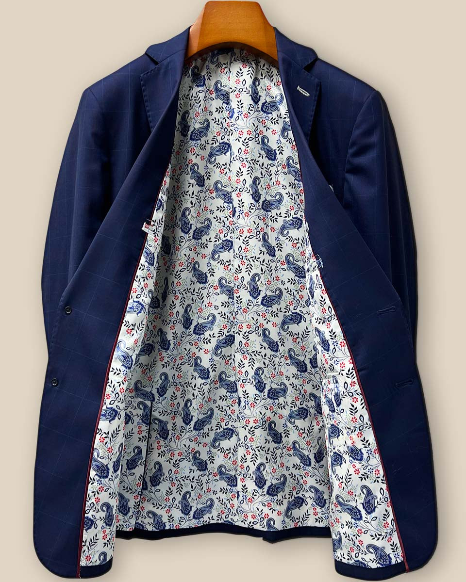 Full view of the luxurious white with navy and red paisley lining of the Westwood Hart suit, showing the craftsmanship of the interior construction
