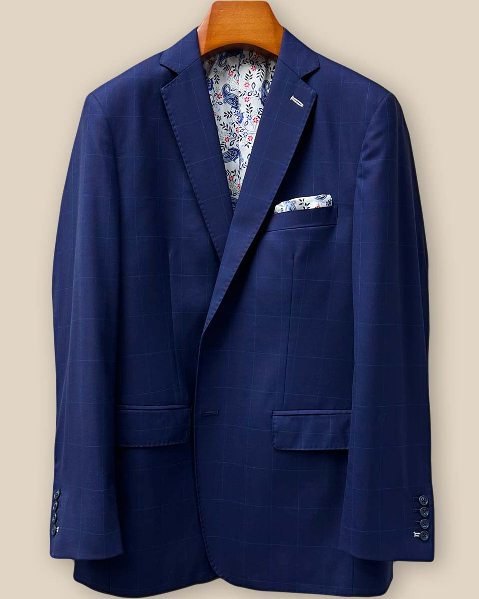 Close-up of navy Super 130's merino wool with red windowpane pattern, showing detailed white contrast buttonhole stitching on the jacket panel