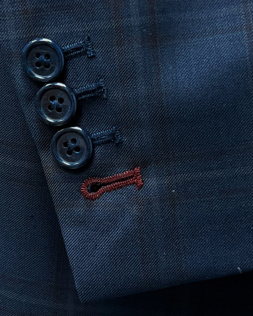 Close-up view of the sportcoat's contrast accent buttonholes with maroon stitching.