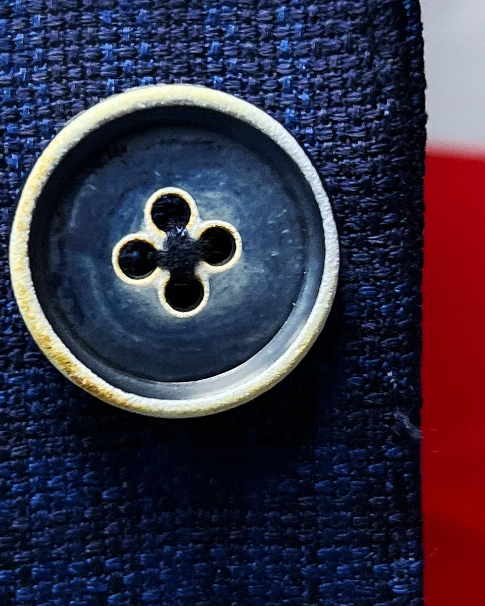 Detailed view of the distinctive blue bone buttons with white trim, showcasing their natural variation and premium quality