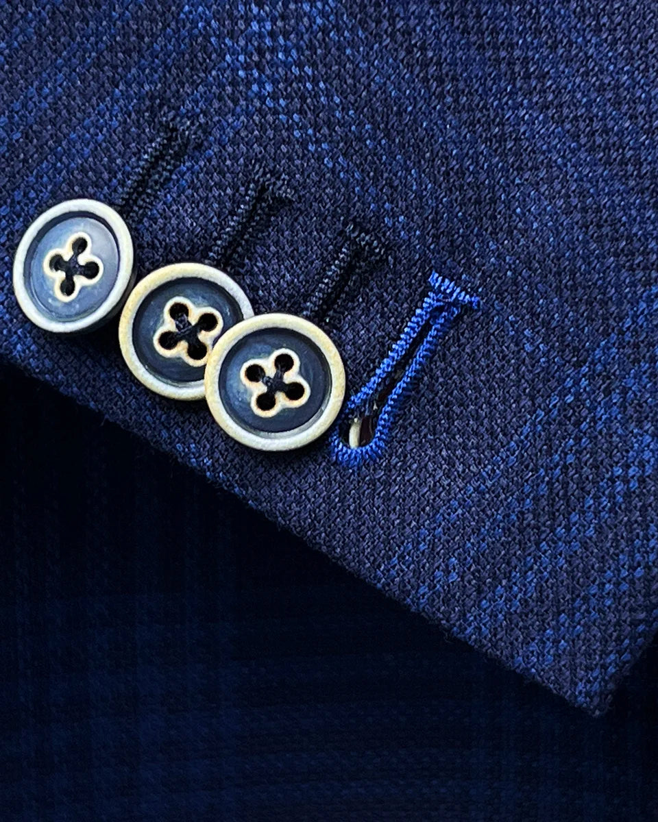 Close-up of the functional sleeve cuffs showing working buttonholes with the last button featuring royal blue contrast stitching as a bespoke detail