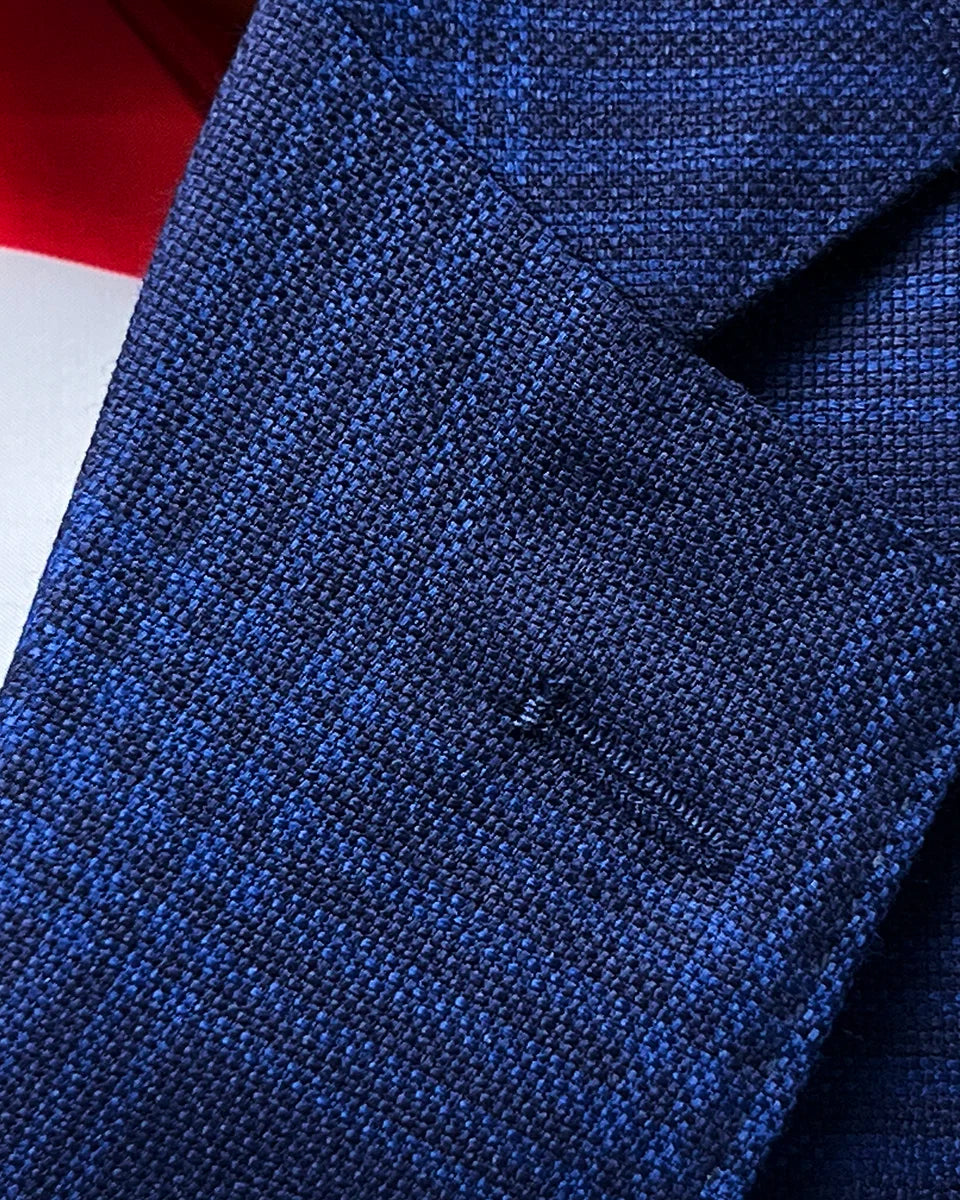 Detail of the classic notch lapel with precise hand pick stitching on the premium blue windowpane Zegna wool-silk fabric