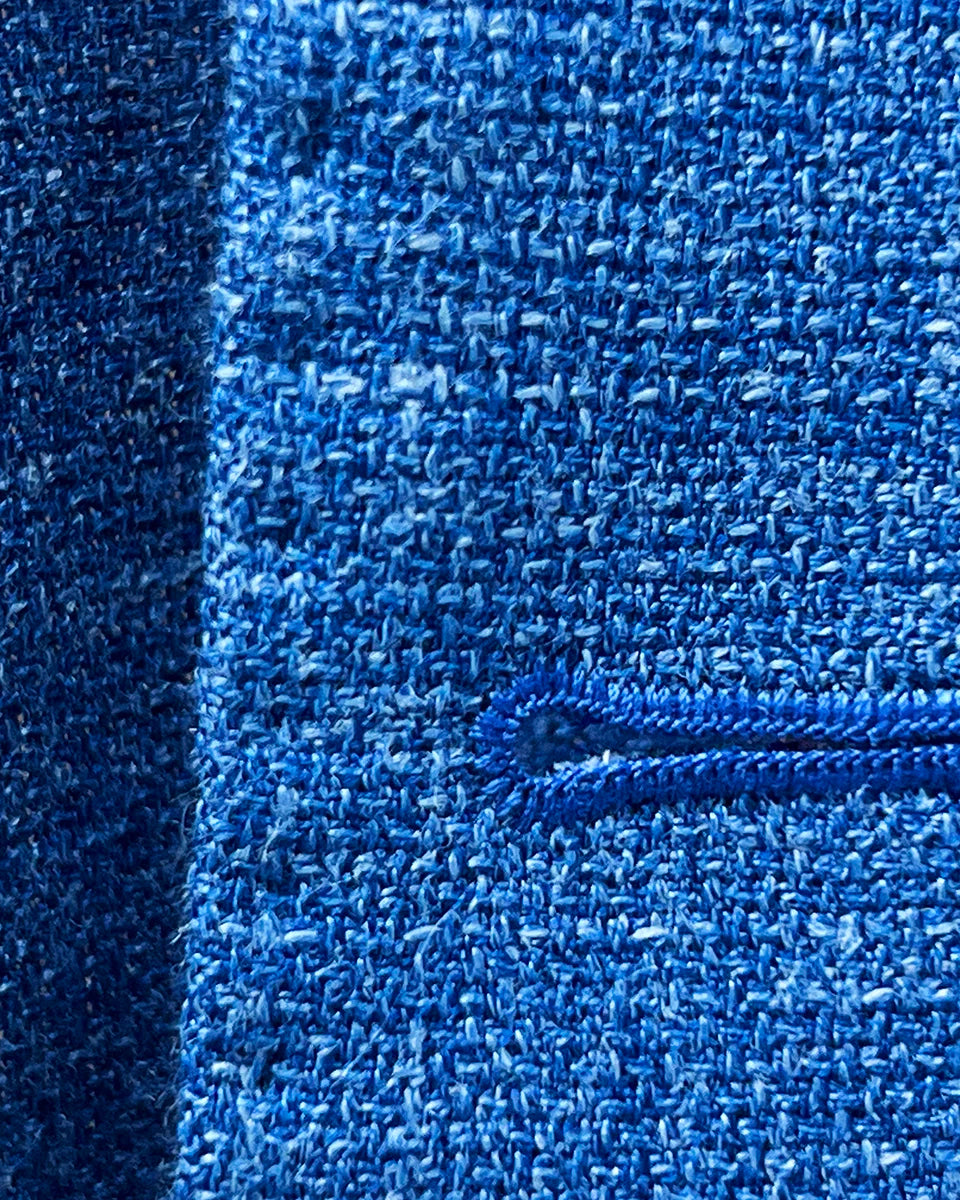 Close-up of the buttonhole stitching on the sportcoat, showing the precise matching pick stitching and fabric texture.