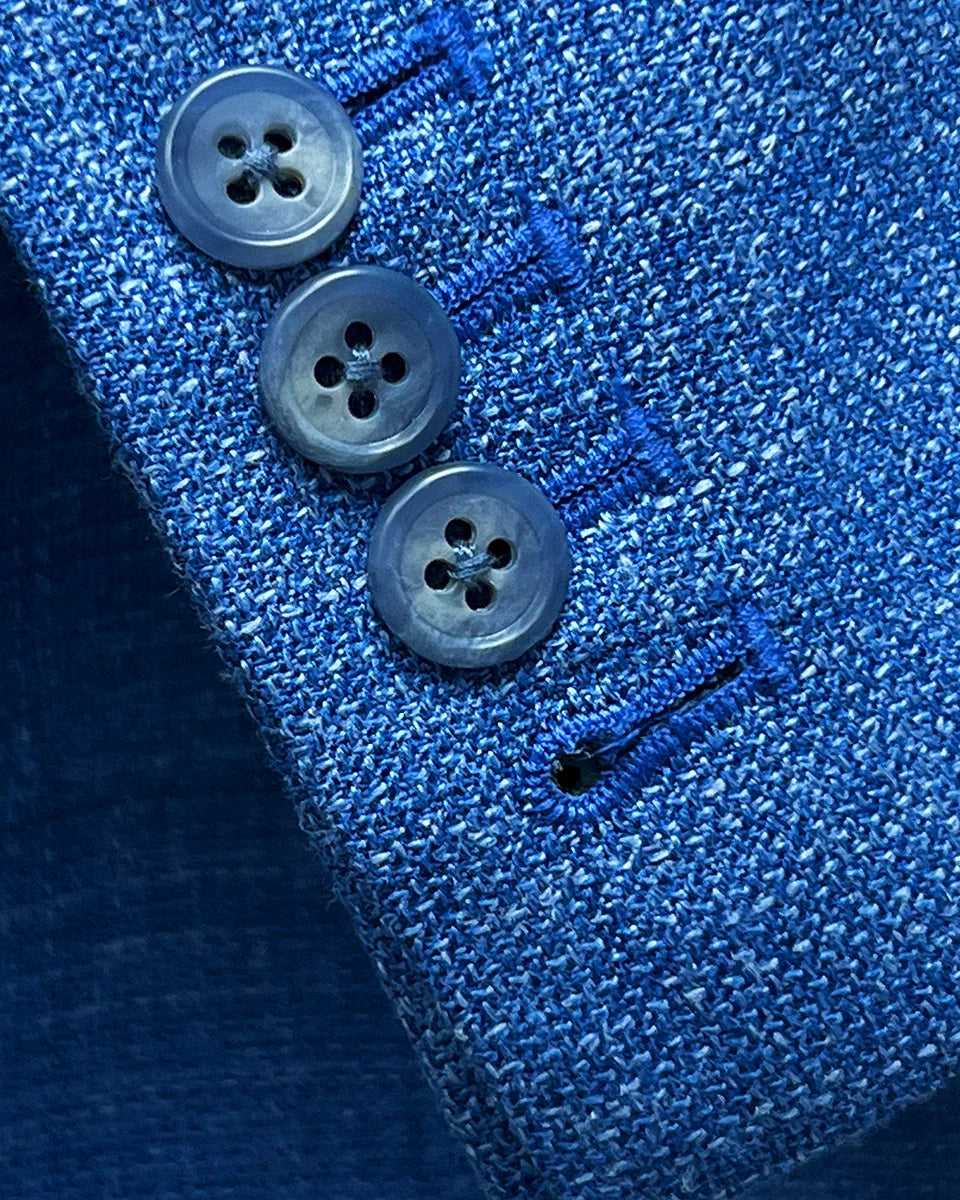 Functional sleeve buttonholes on the sportcoat, featuring matching pick stitching and blue horn buttons.