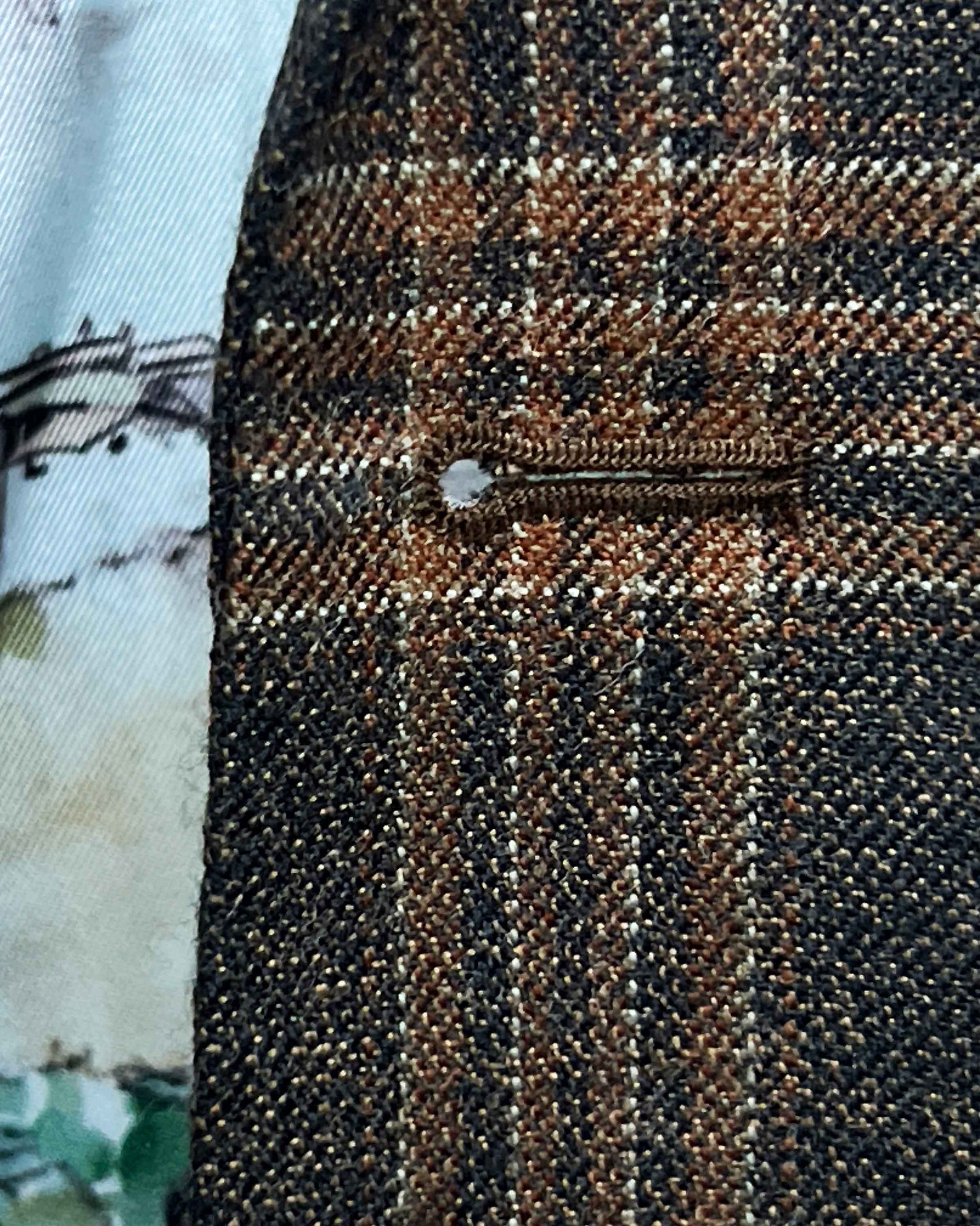 Detailed macro shot of hand-sewn Milanese buttonhole stitching on brown rust block windowpane sport coat lapel