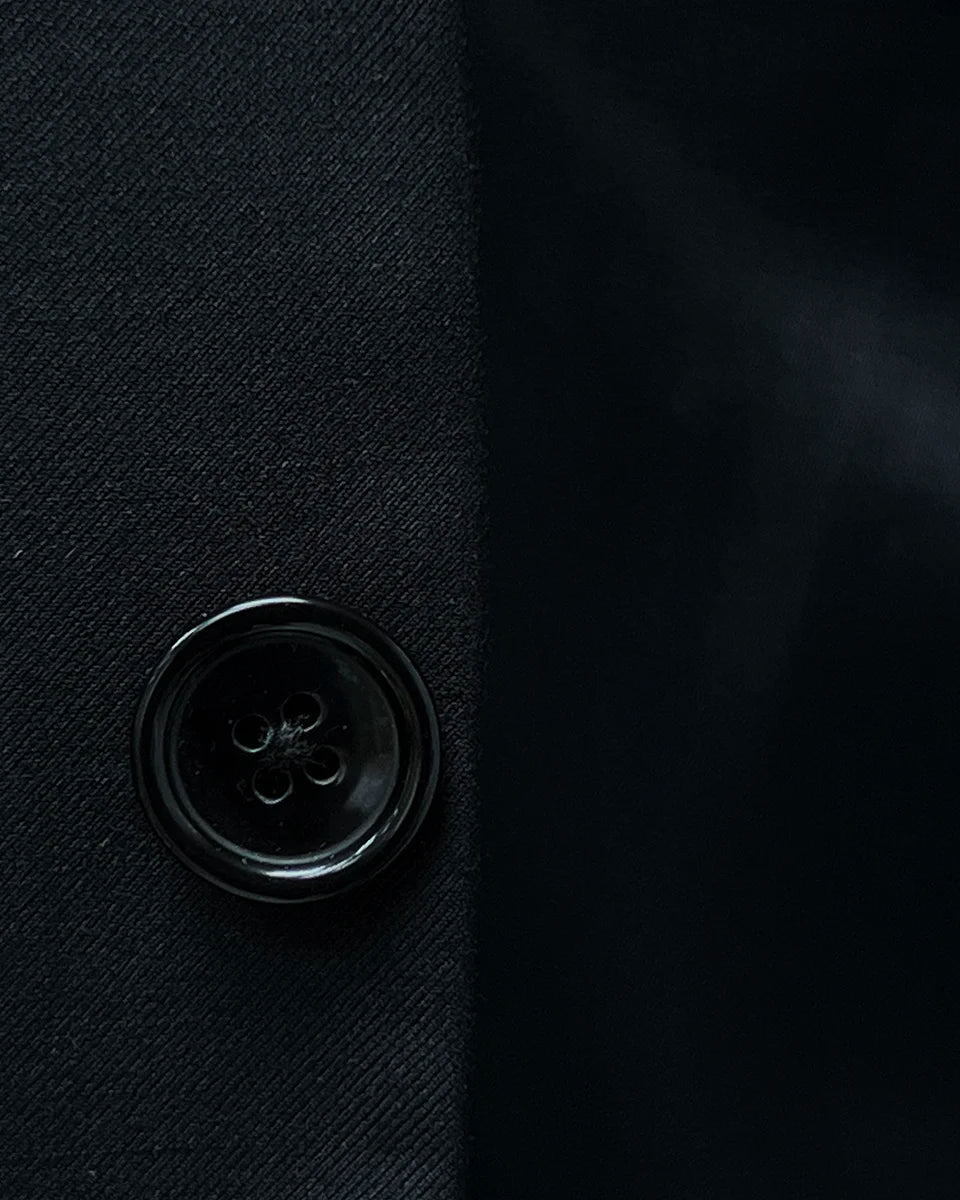 Horn buttons enhancing the traditional elegance of a classic black men's suit.