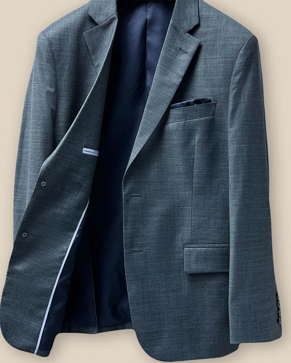 Inside view of the jacket showcasing the lining and construction of a dark grey nailhead suit.