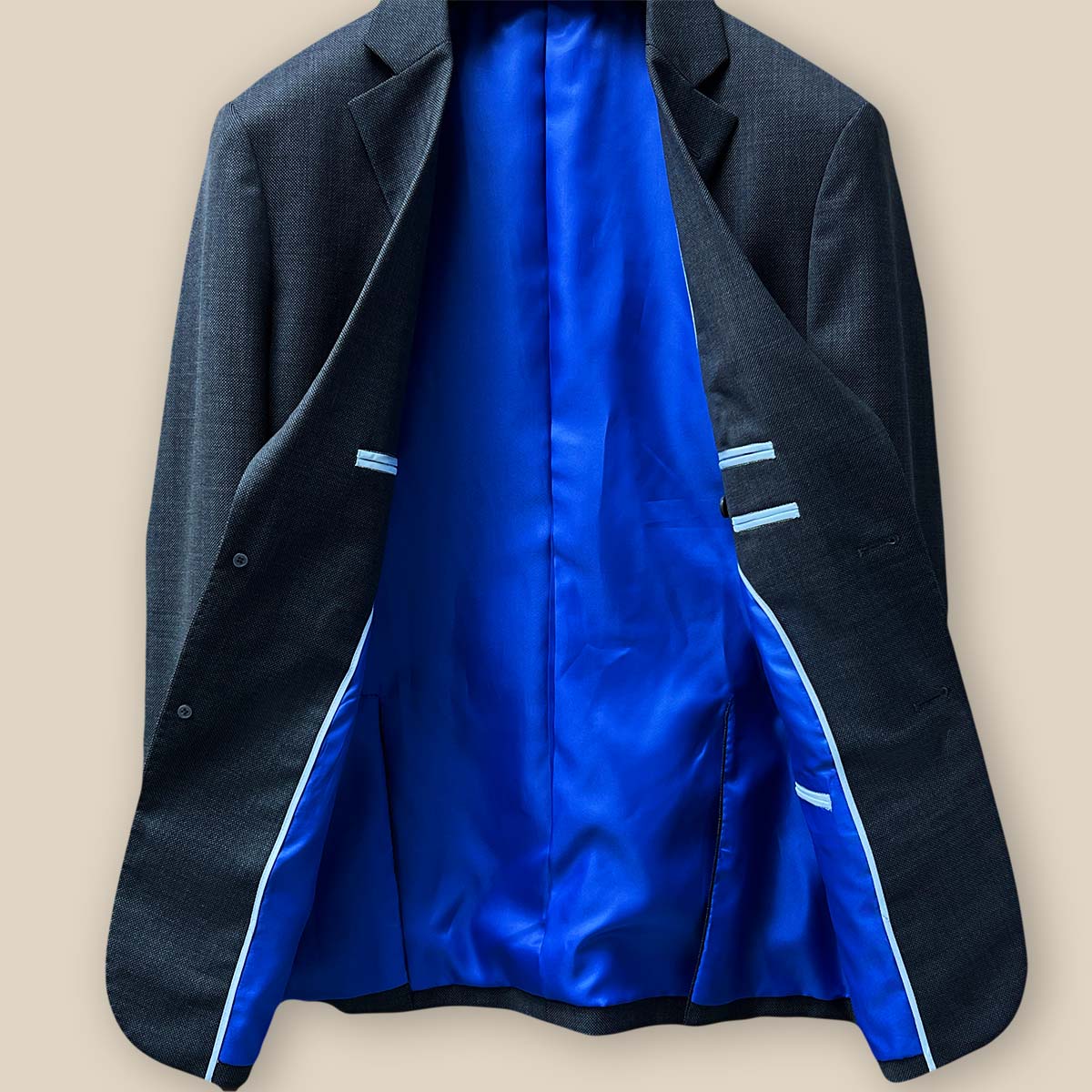 Interior view of the jacket displaying the fine craftsmanship in a dark grey birdseye suit.