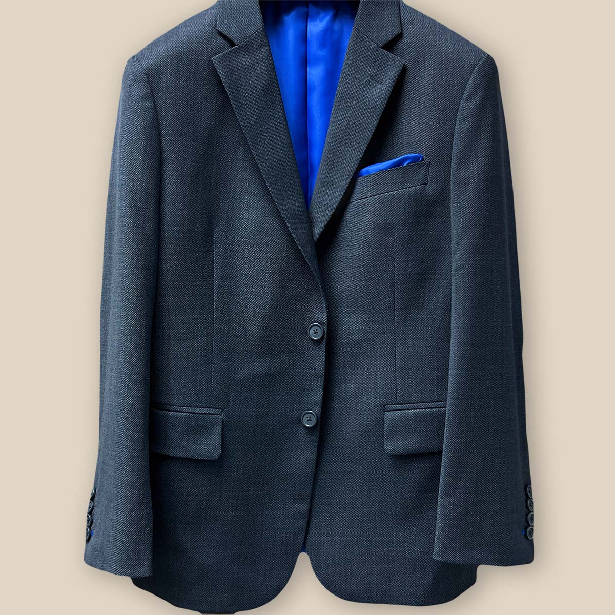 Detailed view of the button panel showcasing the button arrangement on a dark grey birdseye suit.