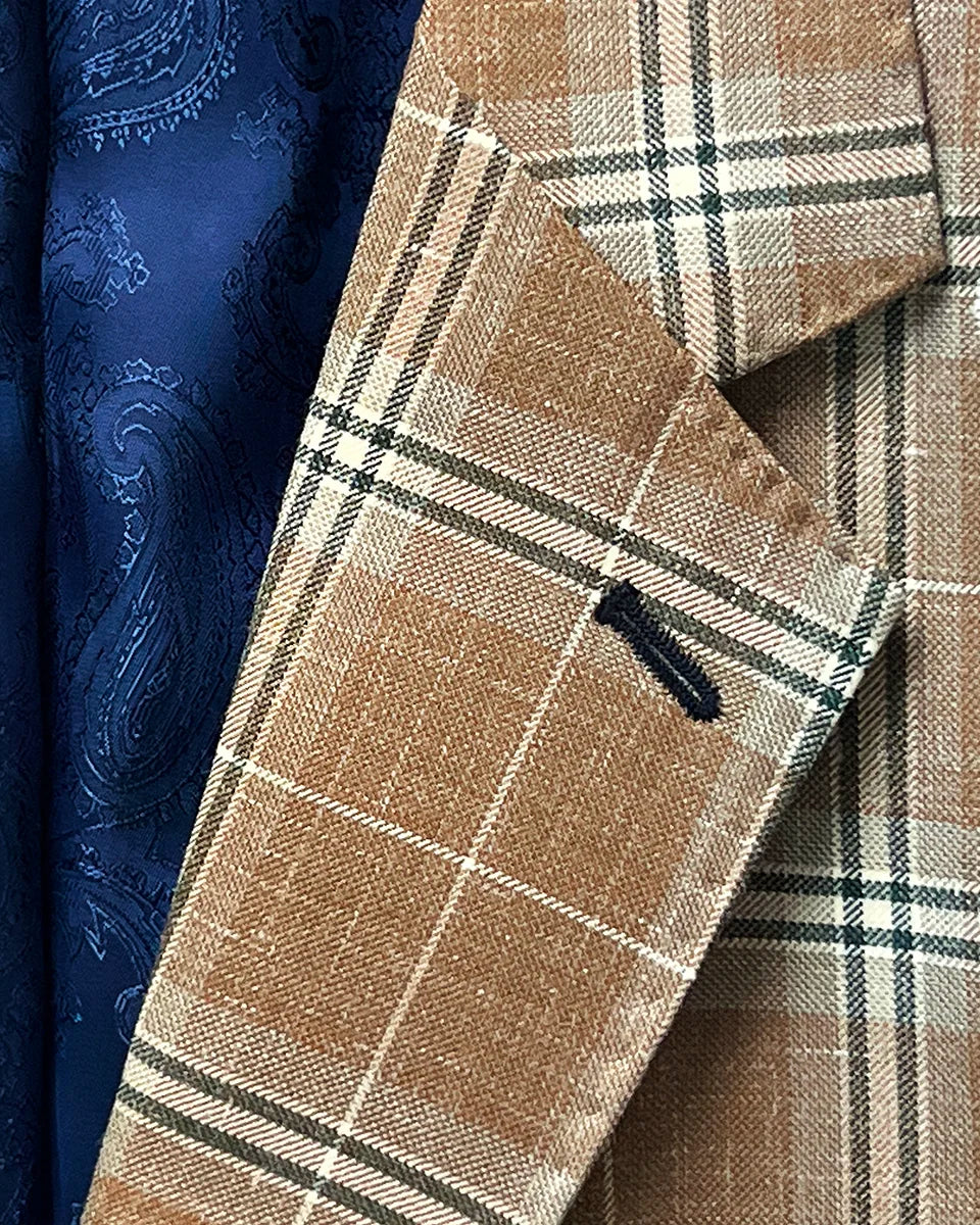 Lapel buttonhole detailing on a brown beige men's sport coat with blanched almond and midnight blue windowpane pattern.