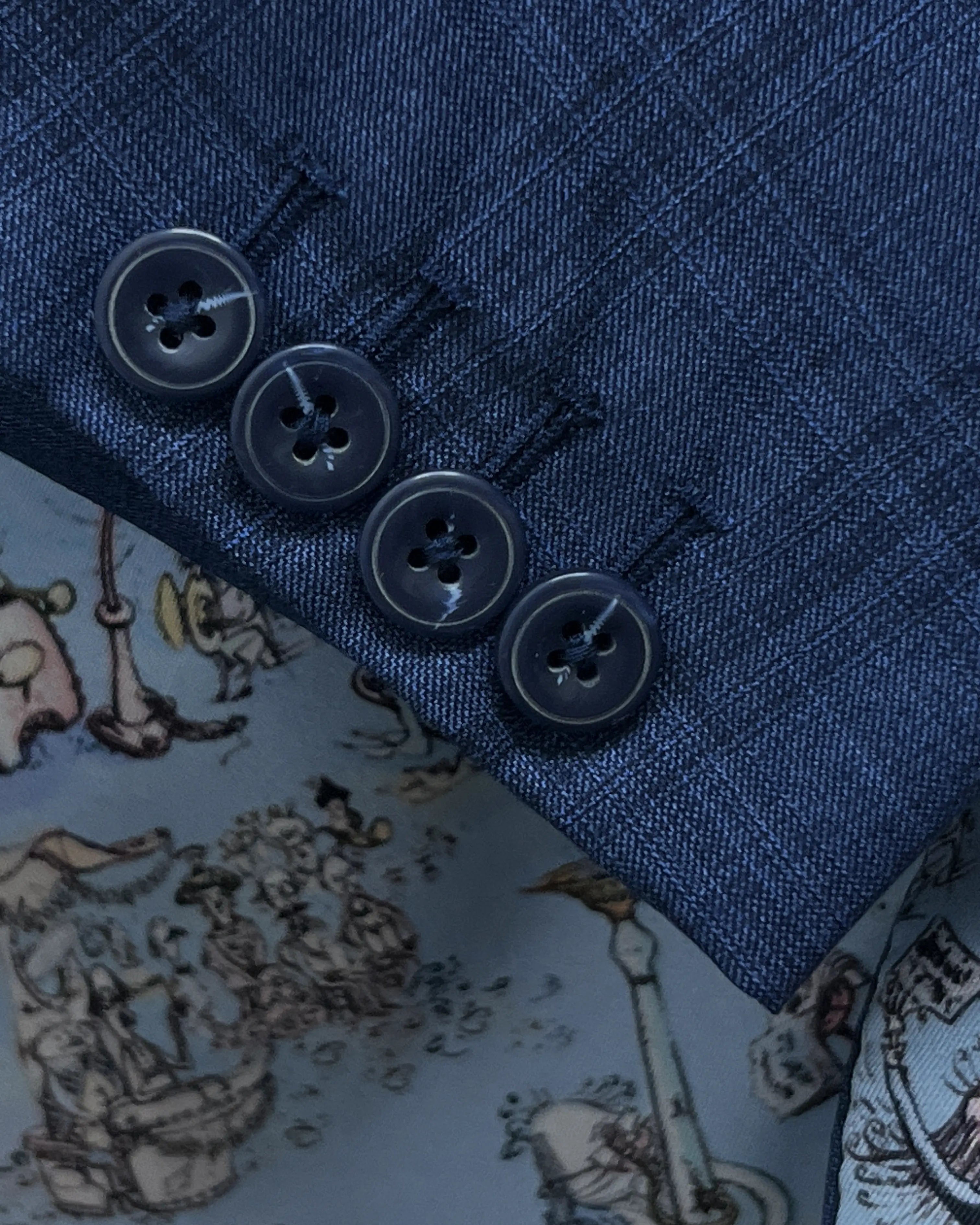 Sleeve cuff detail of blue windowpane check men's suit showing functional sleeve buttons