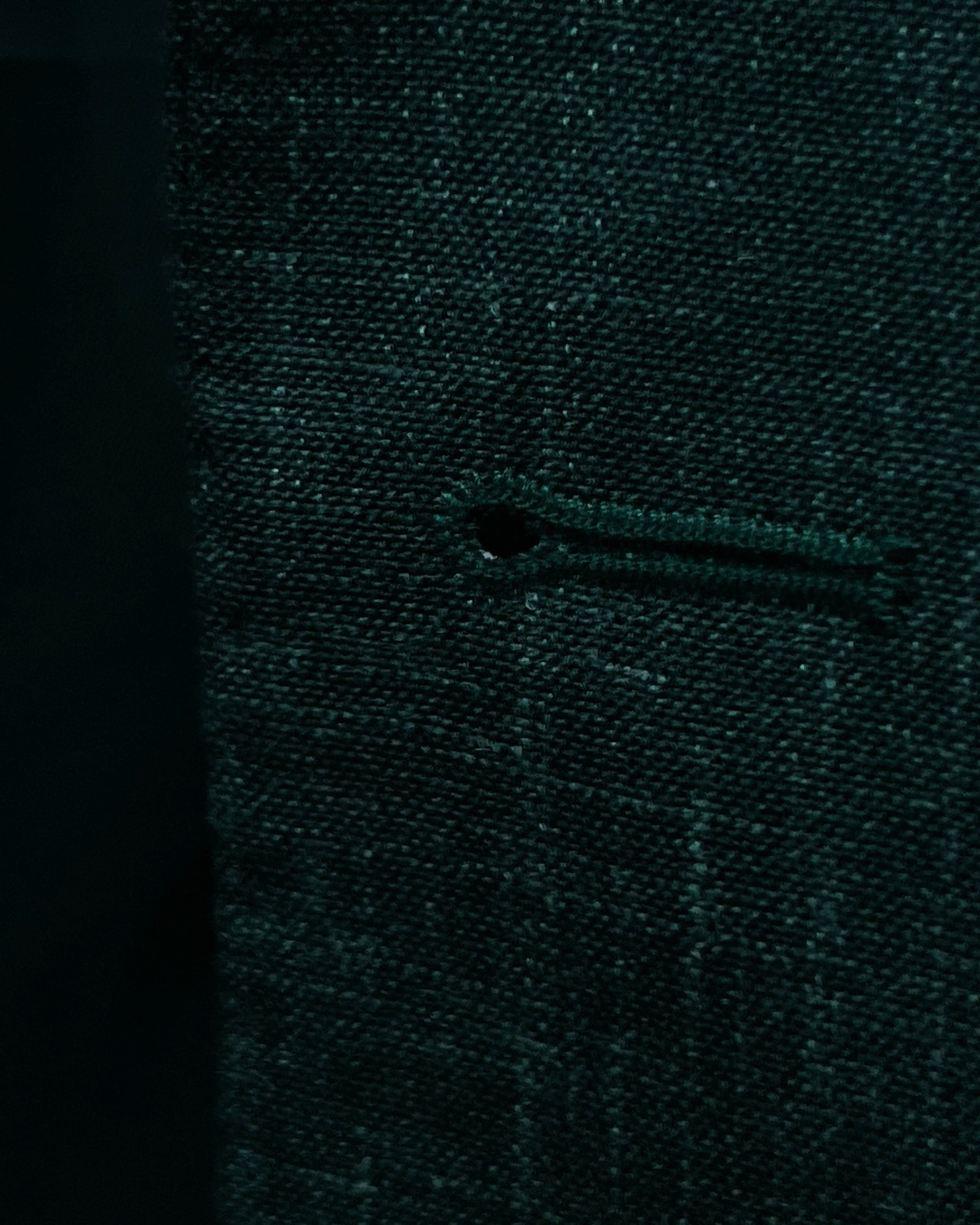 Buttonhole detail image of deep green solid men's suit showing front buttonhole finishing