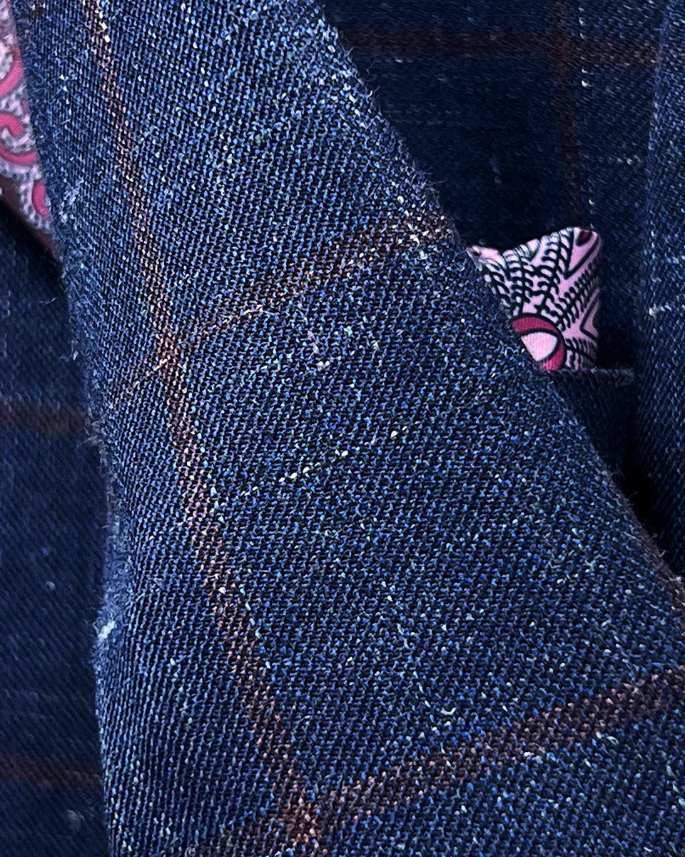 Detailed view of hand-picked stitching along lapel edges and seams of navy windowpane sport coat showing artisan craftsmanship