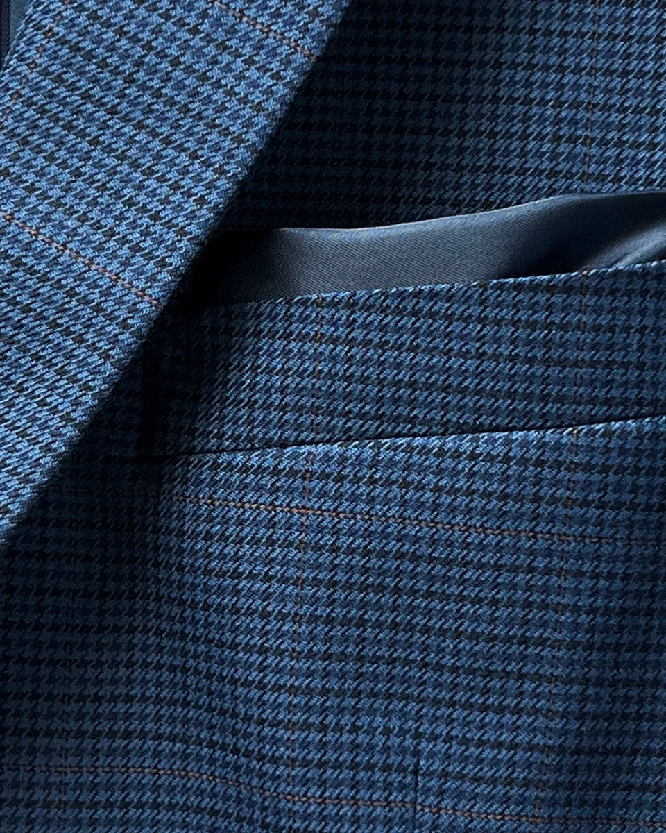 Built-in pocket square detail on the prussian blue suit jacket, adding a touch of elegance and practicality.
