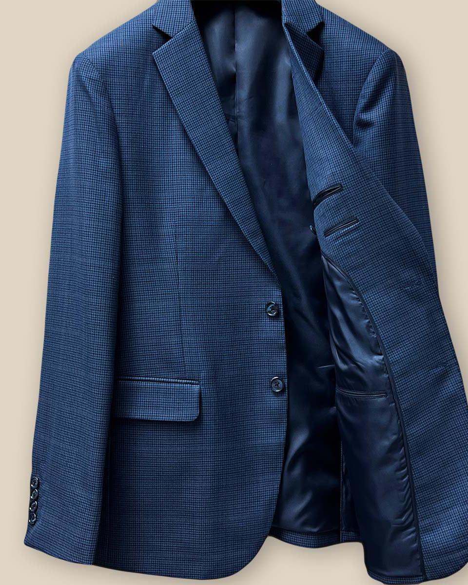 Interior view of the left side of the prussian blue suit jacket, highlighting the dark blue bemberg plain lining.