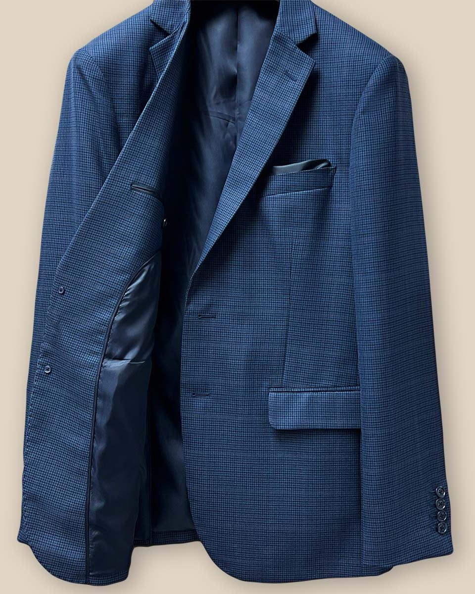 Interior view of the right side of the prussian blue suit jacket, showing the fine craftsmanship and dark blue bemberg lining.