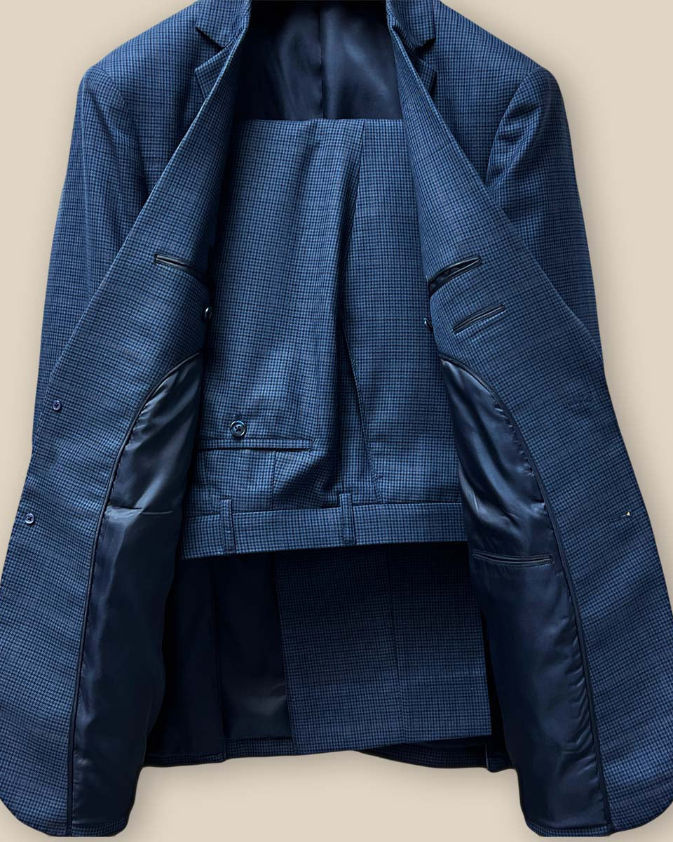 Full view of the prussian blue two-piece suit, displaying the elegant houndstooth with faint pastel orange windowpane design.