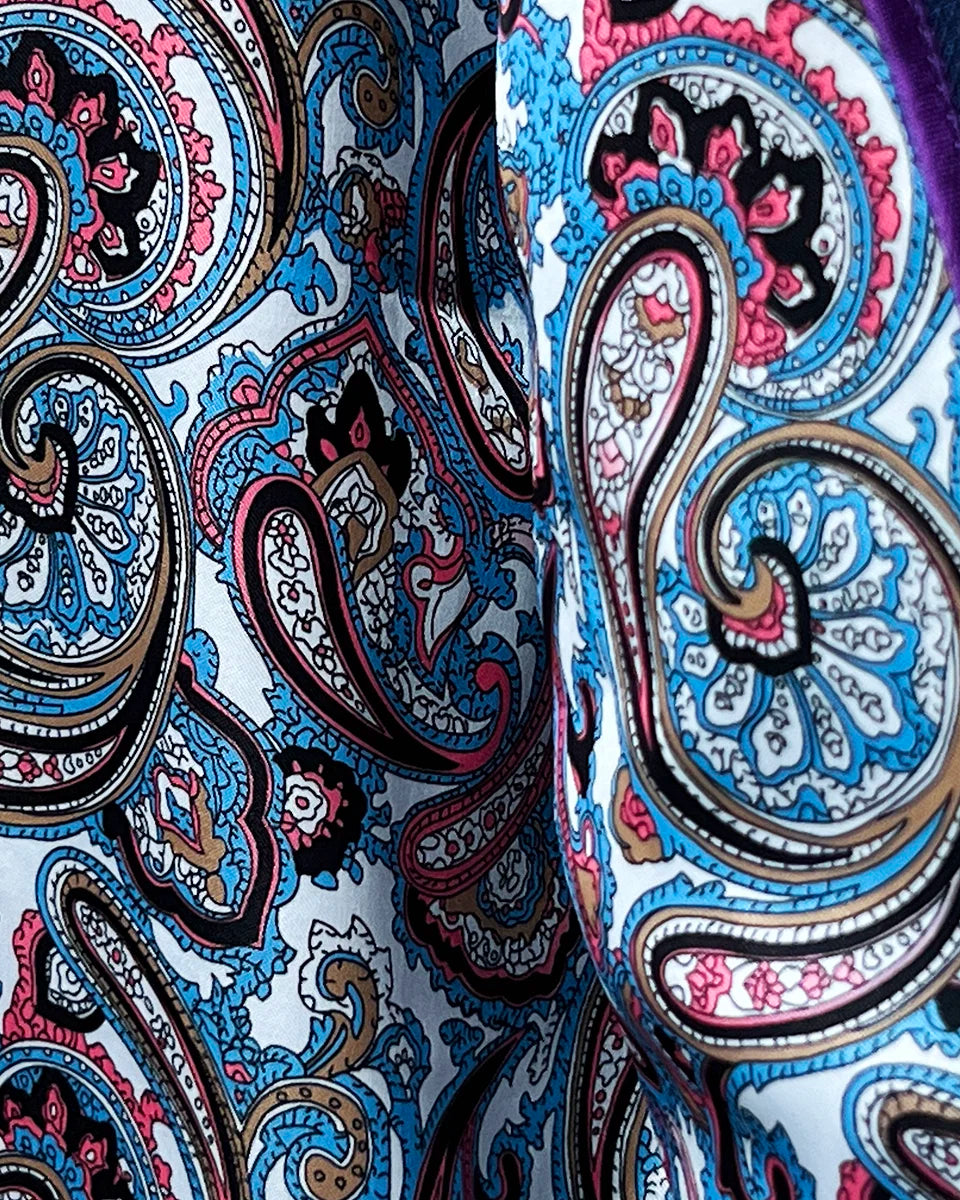 View of the flash linings with a multi-color paisley print inside the royal blue suit jacket.