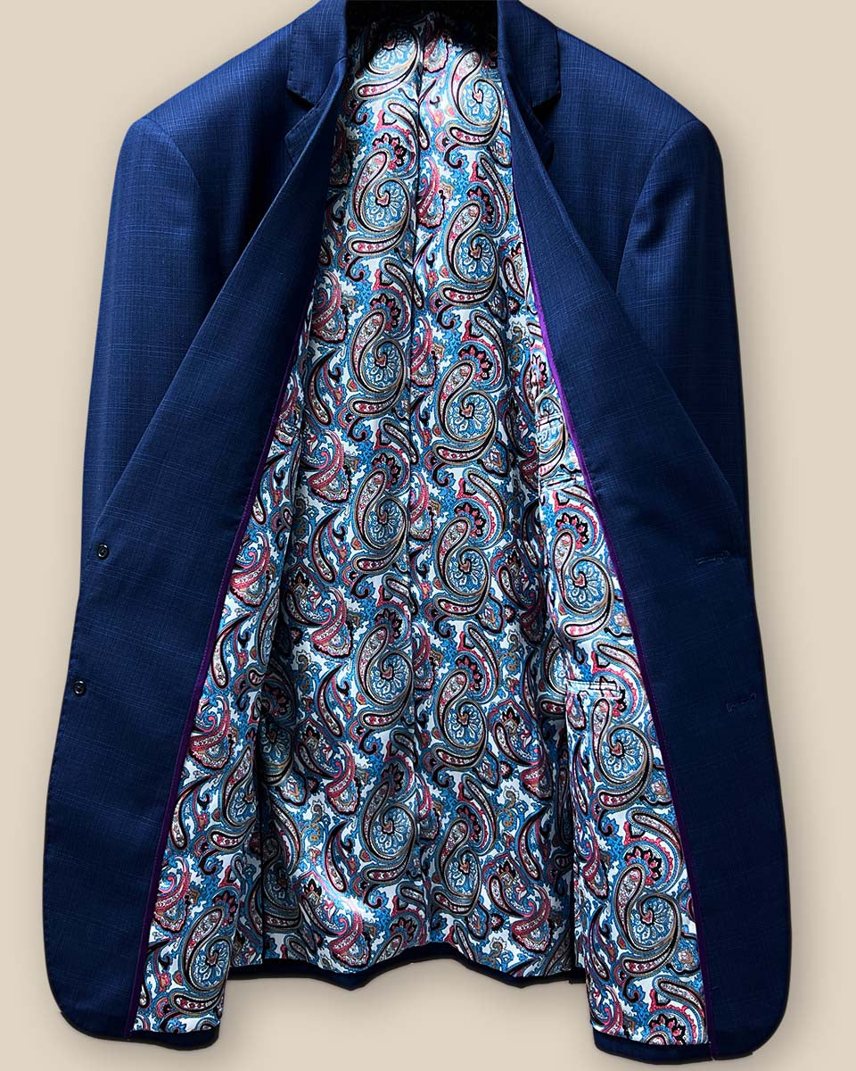 Full inside view of the royal blue suit jacket highlighting the vibrant paisley print lining.