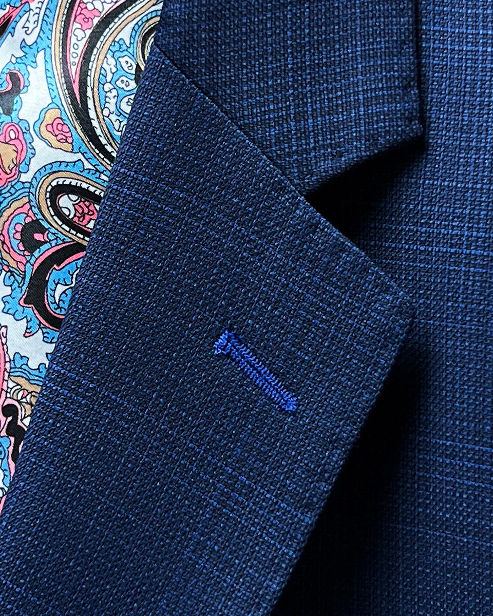 Detailed view of the notch lapel with pick stitching and royal blue contrast buttonhole.