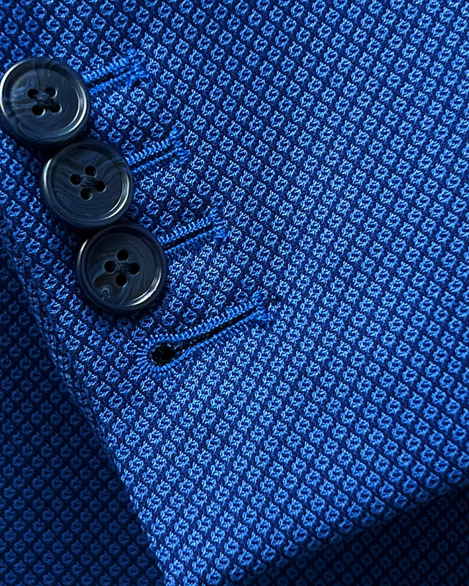 Close-up view showing the functional sleeve buttonholes with contrast stitching on the sapphire blue men's suit, enhancing its functionality and style.