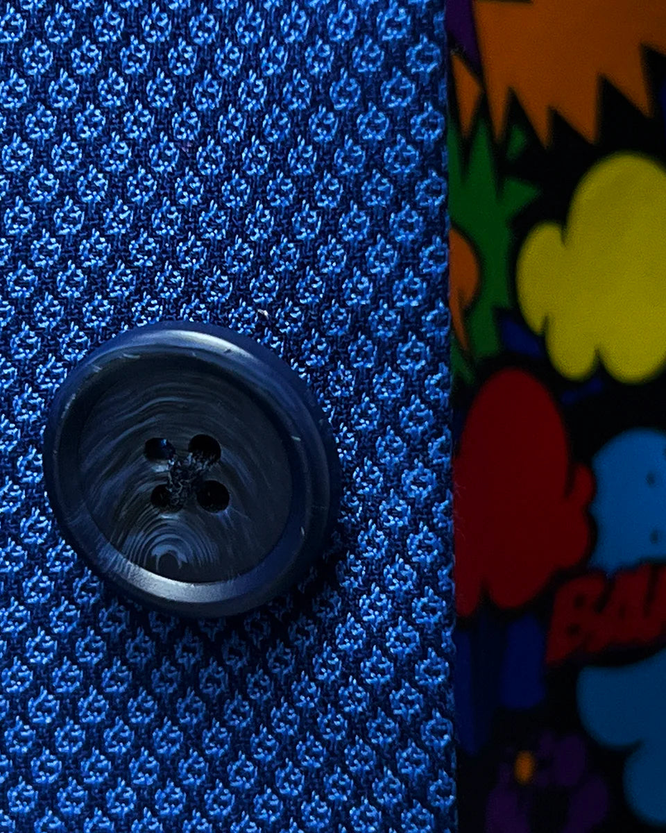 Close-up of the navy blue horn marble buttons on the sapphire blue men's suit, showcasing their elegant and polished finish.