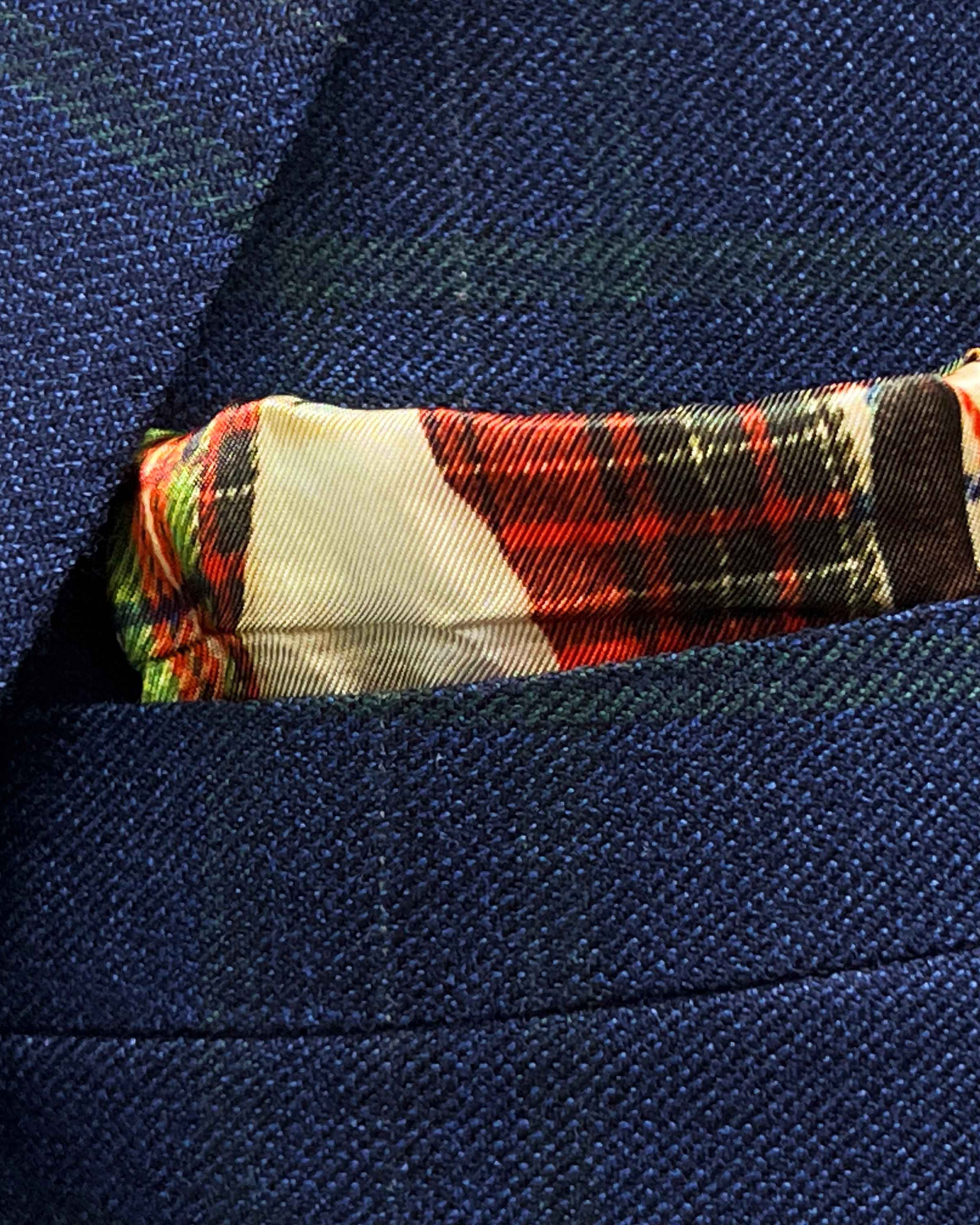 Breast pocket of deep blue navy emerald green overcheck suit jacket with built-in pocket square holder and hand-finished edges