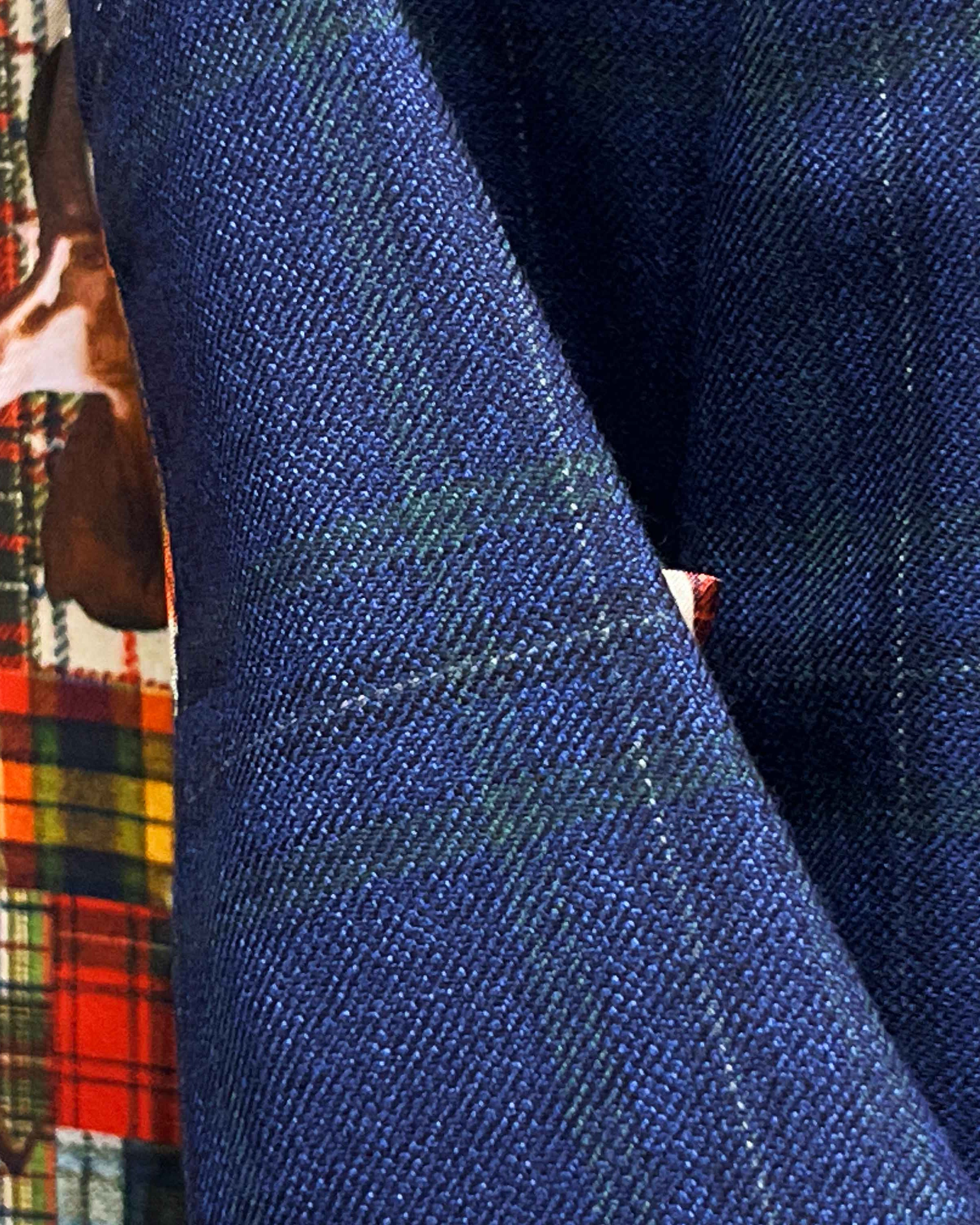 Macro detail of Scabal deep blue navy emerald green overcheck fabric showing twill weave texture and plaid pattern