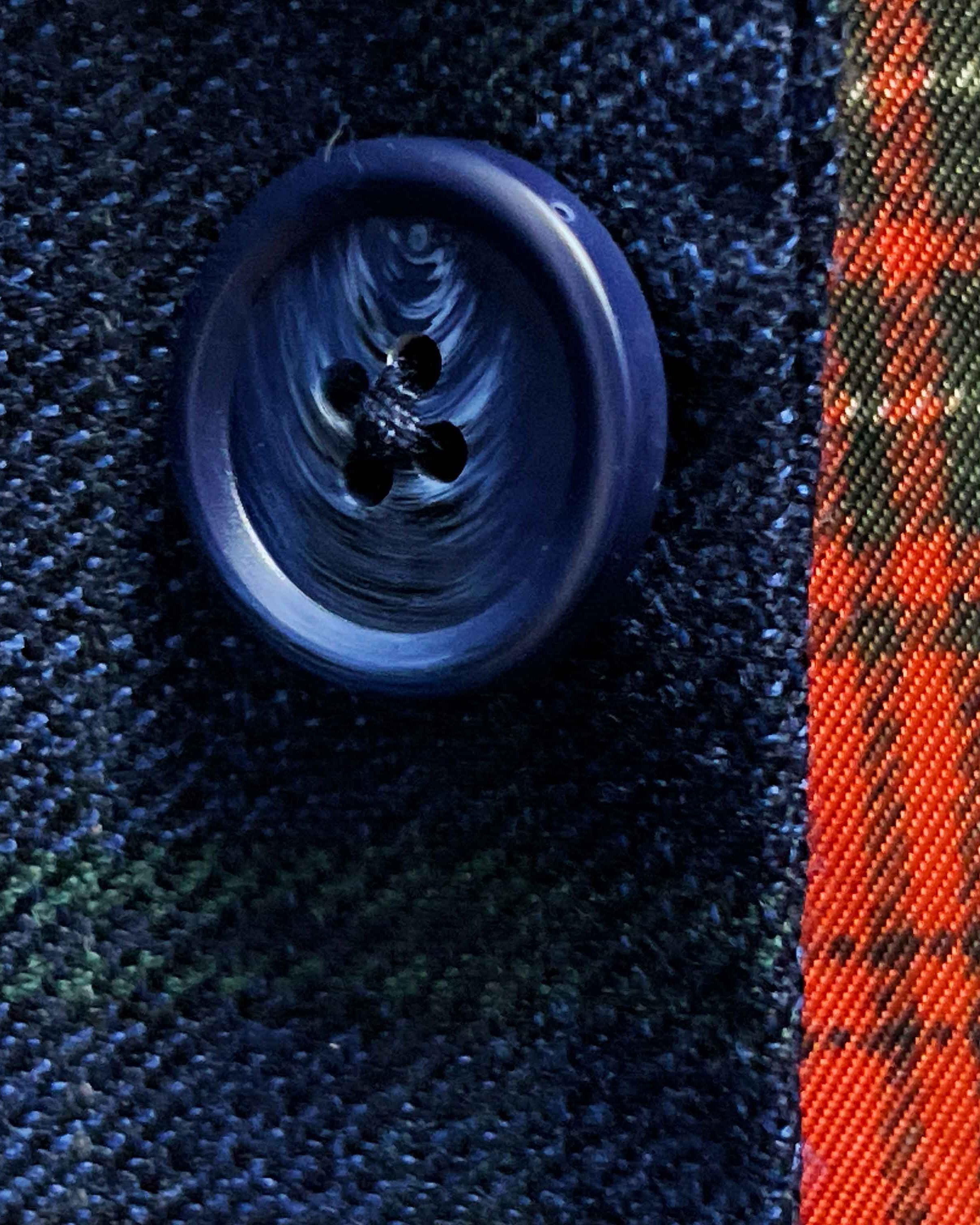Close-up of navy marble horn buttons on deep blue navy emerald green overcheck suit jacket showing natural marble-like patterns