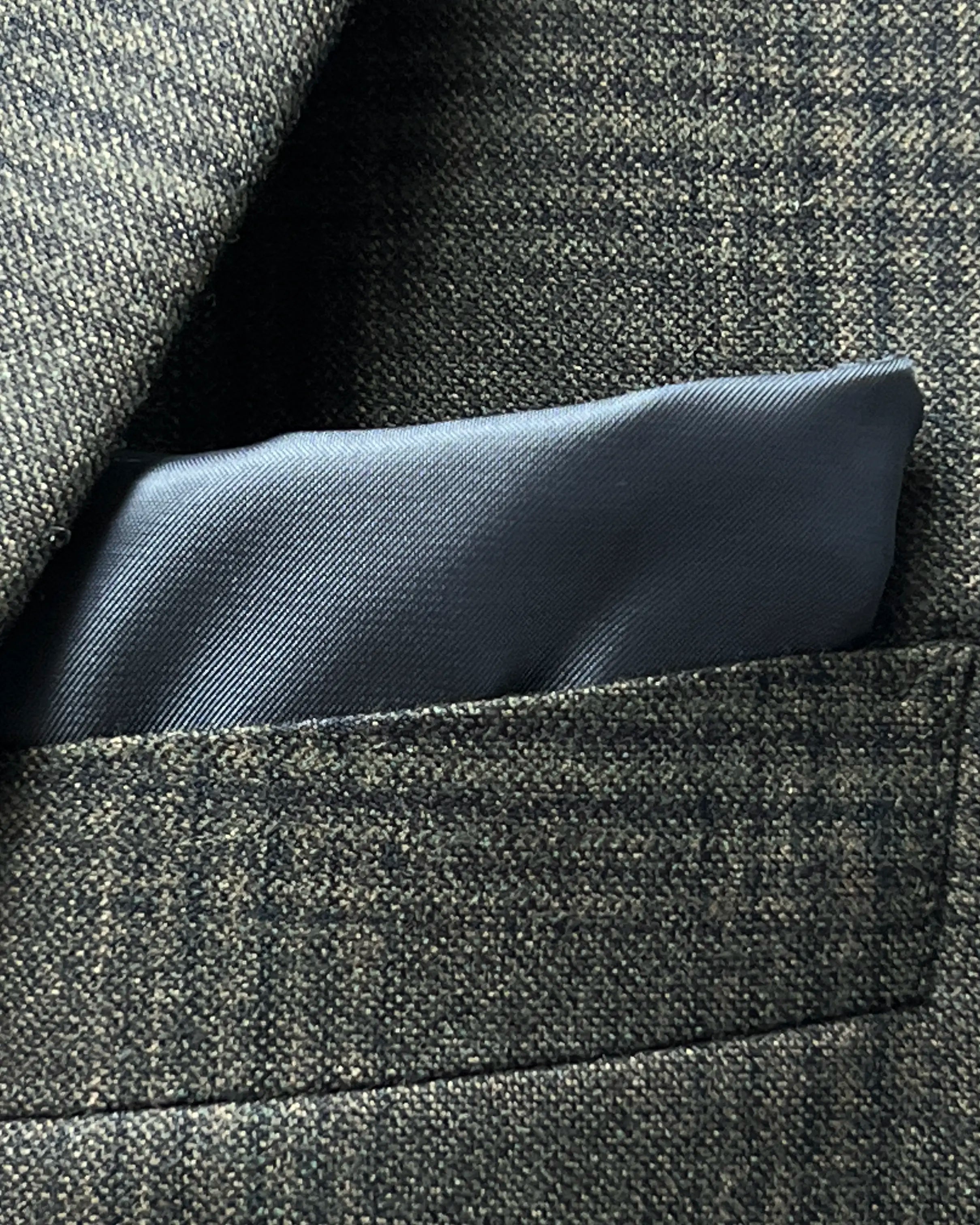 Breast pocket view of charcoal brown melange tonal Glen Plaid men's sport coat showing the matching medium grey cupro silk bemberg pocket square.