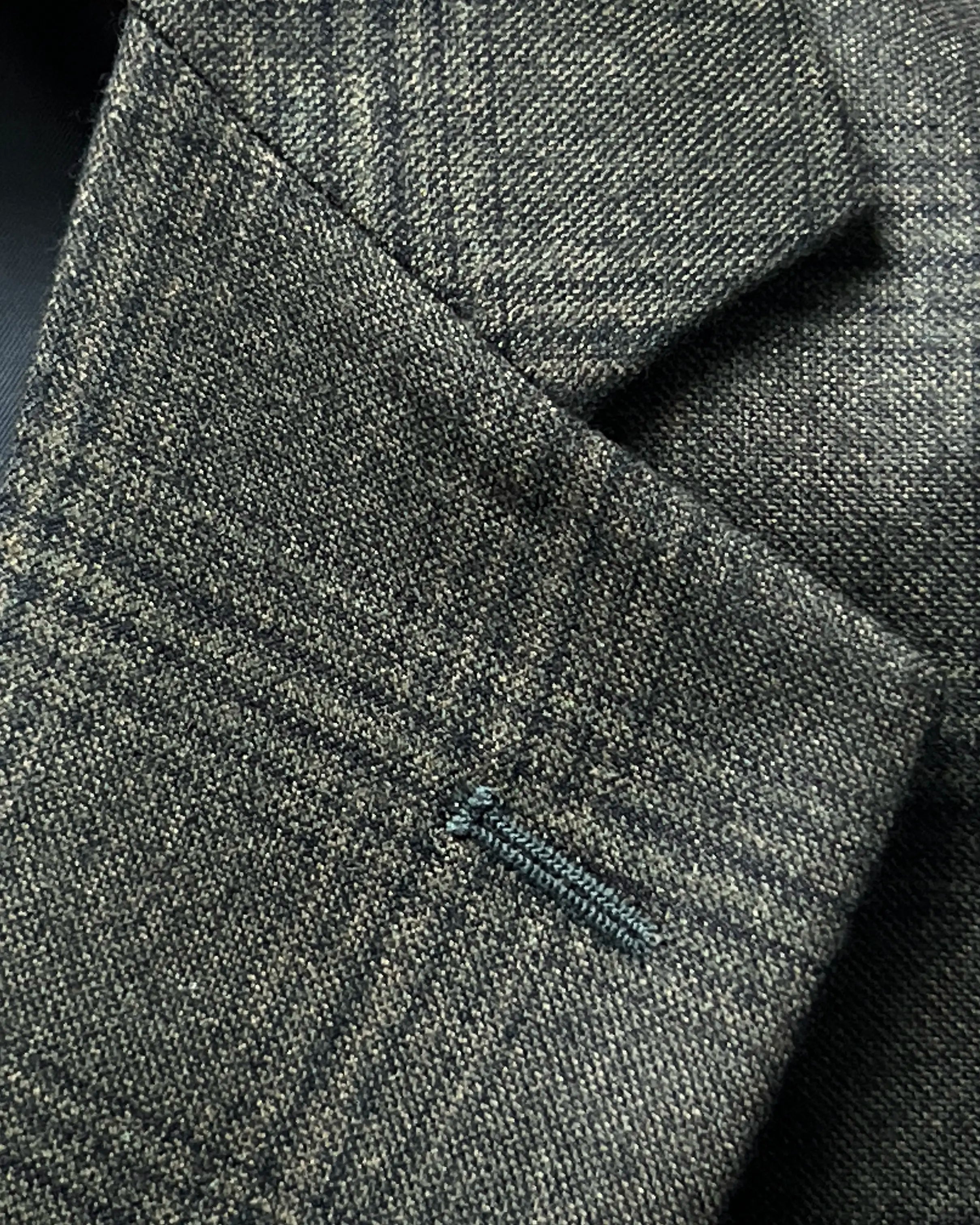 Lapel buttonhole close up of charcoal brown melange tonal Glen Plaid men's sport coat showing matching stitching.
