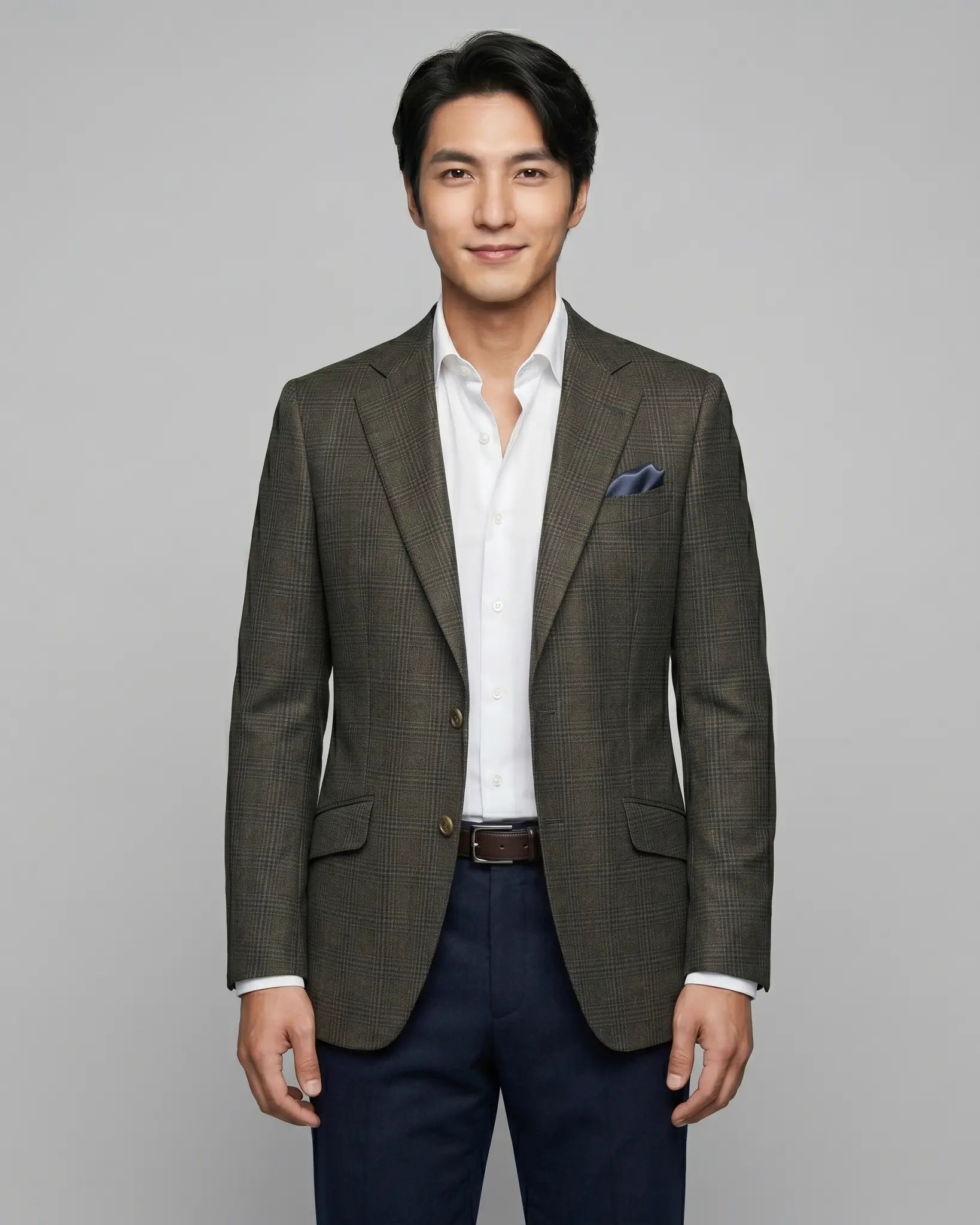 Front model view of charcoal brown melange tonal Glen Plaid men's sport coat showing the tailored front, notch lapels, slanted flap pockets, and matching pocket square.